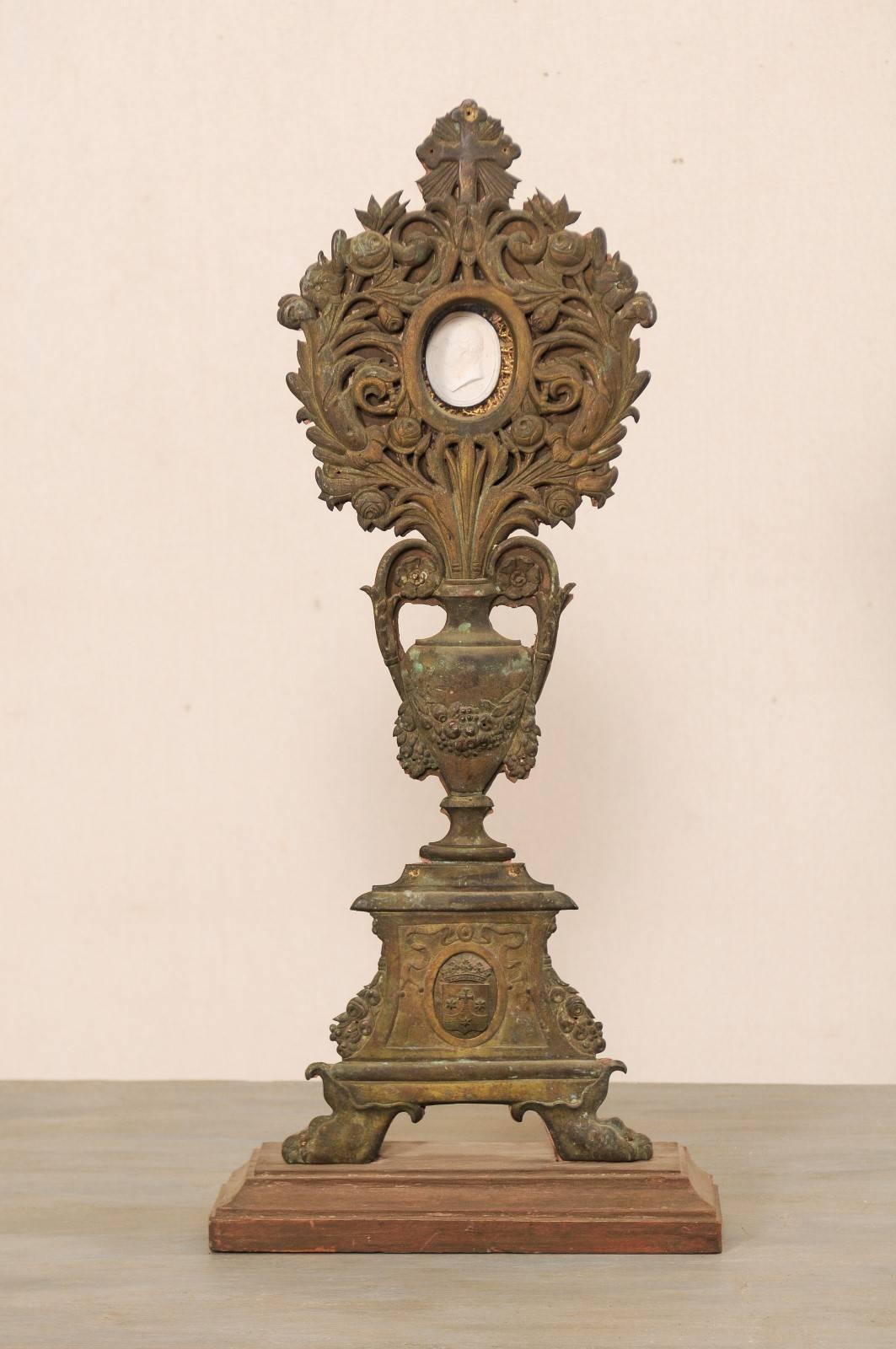 A French 19th century altarpiece with intaglio. This antique French altarpiece features an urn and floral motif, with a single intaglio set into the central top bouquet. This altarpiece, with its nicely decorated repoussé (a technique in which the
