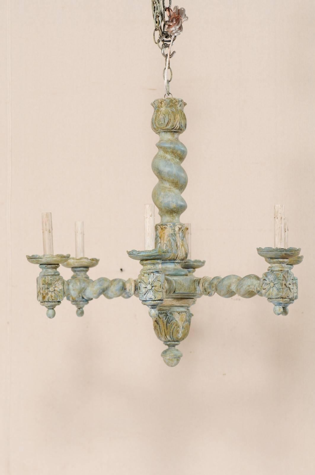 A French six-light, barley twist painted wood chandelier. This French vintage painted wood chandelier features a central barley twist column with acanthus leaf motifs from the upper and lower ends. Six barley twist arms extend out from the central