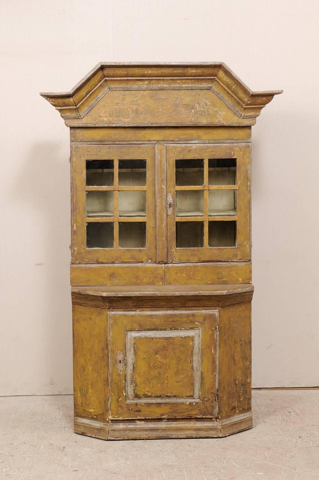 An 18th century Swedish cupboard. This Swedish cabinet, circa 1725-1750 is the perfect transition between Baroque and Rococo. The cupboard retains its original paint and hardware. This piece features a robustly trimmed pediment bonnet. There are two