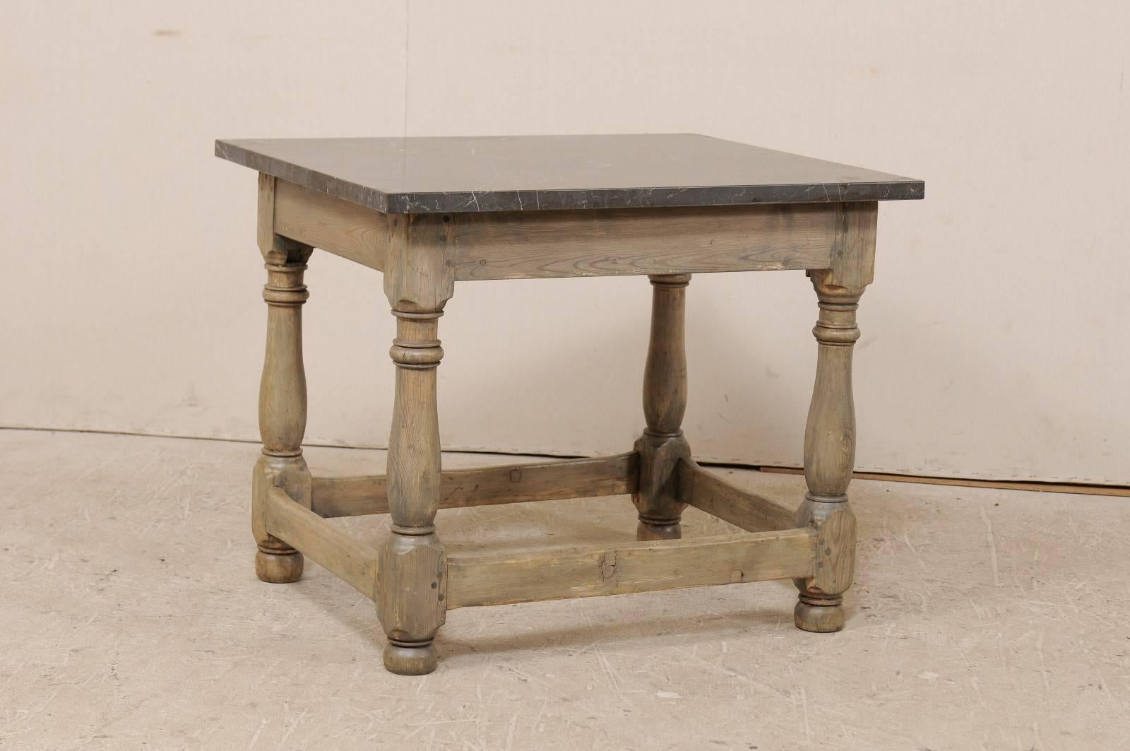 A Swedish 18th century table with honed marble top. This Swedish occasional table features a honed marble top resting upon a wood frame with four turned legs. The skirt is clean and simple and there are bottom stretchers between each leg along all