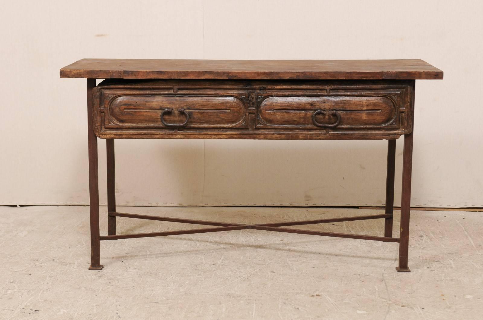 A custom table fashioned from an 18th century, Spanish drawer. This unique table features an exquisite 18th century Spanish wood carved drawer with it's original forged iron hardware. The drawer has been set into a custom patinated iron base and an