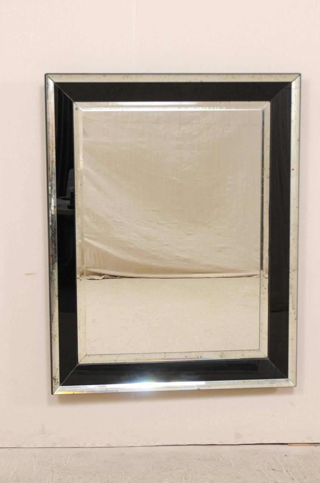 A vintage American large-sized, rectangular shaped mirror with accentuated black and antiqued glass border. This American mirror features a clear centre glass with black glass surround, framed within antiqued glass sections. This distinctive mirror