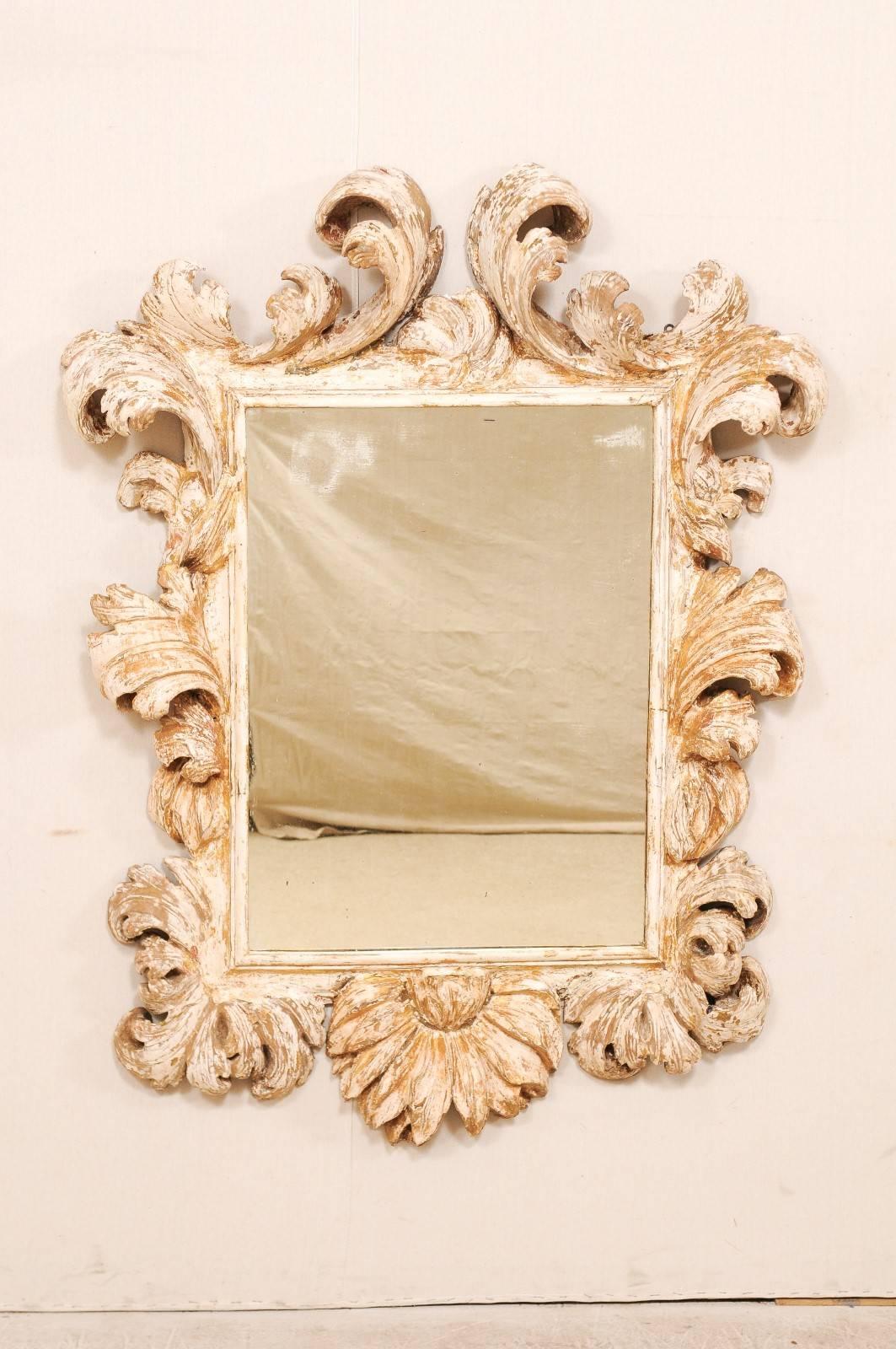 An early 18th century Italian period Baroque beautifully carved mirror. This elaborate antique Italian mirror features a richly carved ornate acanthus leaf surround with gesso and traces of gilt throughout the frame. The carved details are