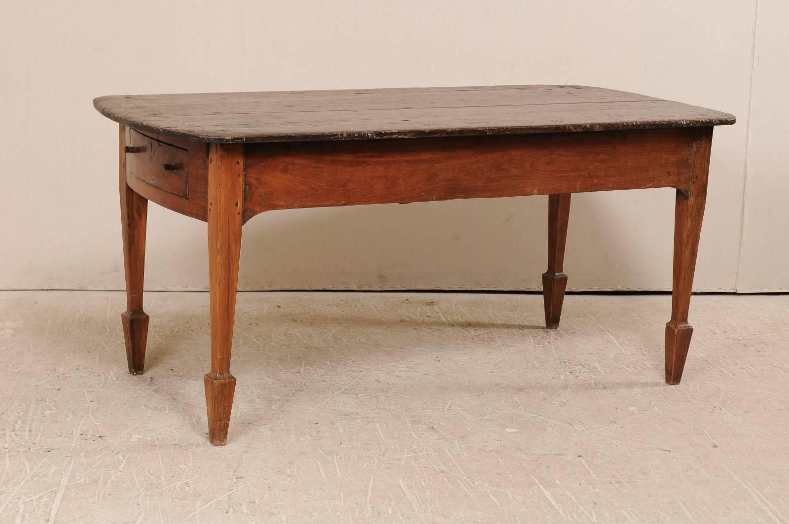 An antique Brazilian table. This Brazilian table, from the early 20th century, features two drawers (one at each far side) and is raised up on squared legs with spaded feet. The table is peroba wood (a tropical native hardwood, 35% harder than oak),