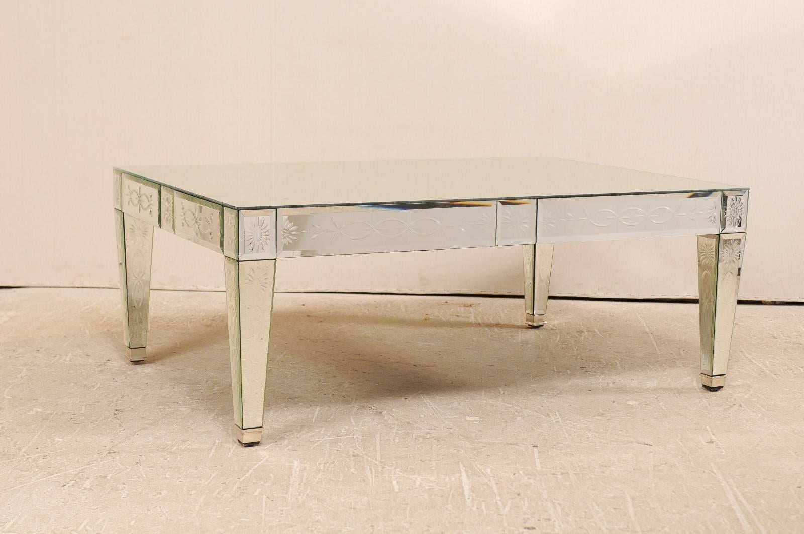 A vintage Venetian style mirror coffee table. This American handmade and hand silvered mirrored coffee table from the late 20th century will add a bit of glamour to your home with its clean lines and refined etched motifs. This table has a mirrored