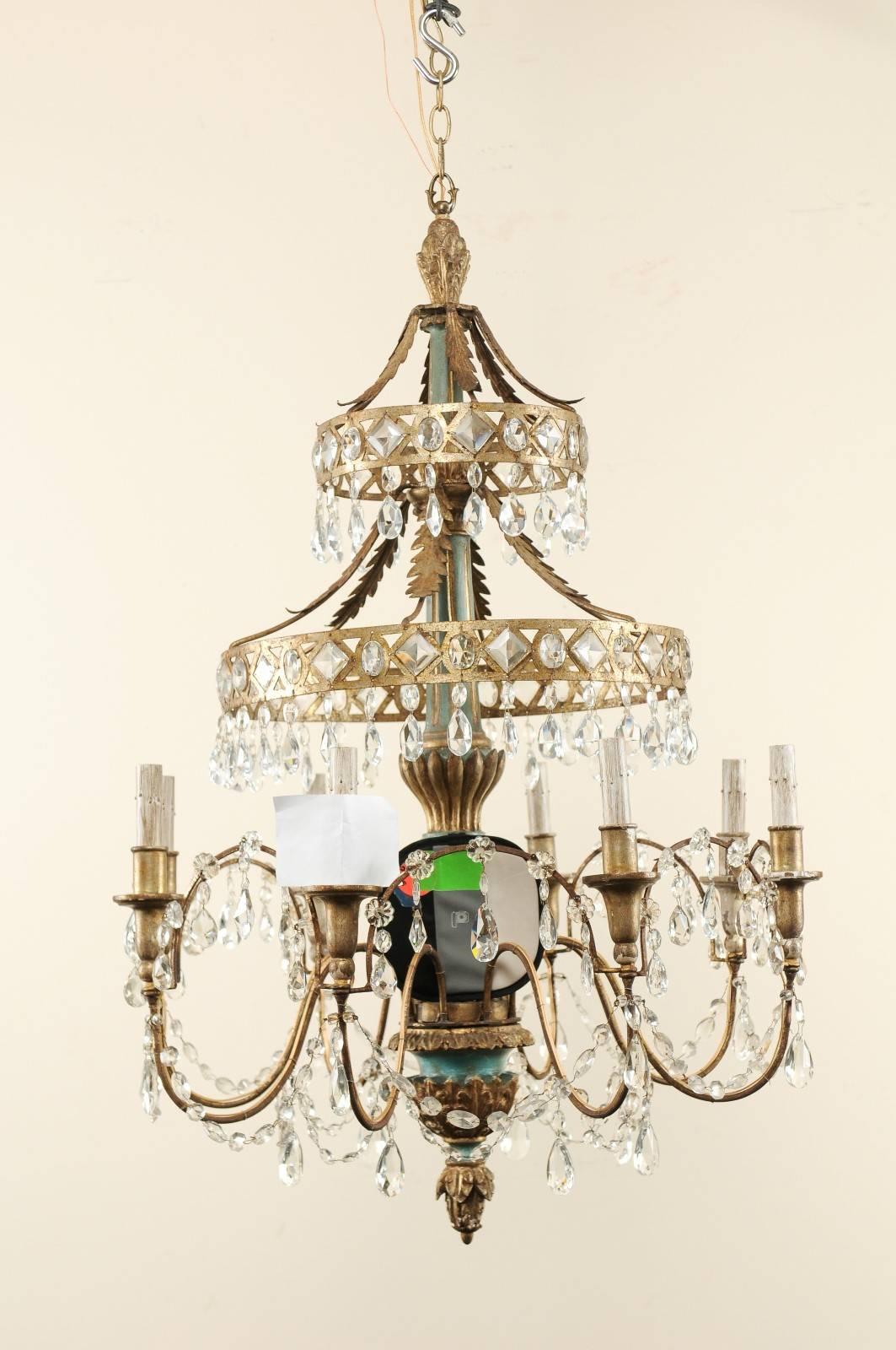 A midcentury Italian eight-light chandelier of crystal, wood, and metal. This unique Italian chandelier from the mid-20th century features a carved wood column, with gilt and gesso, with fluid s-shaped swooping arms lifting up and out from its