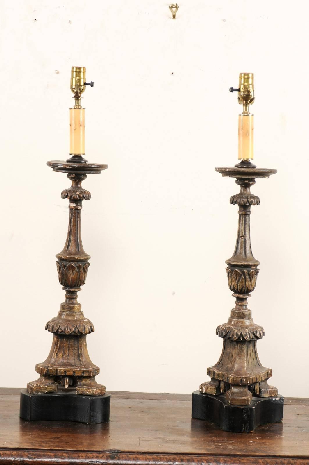 A pair of Italian 19th century carved wood altar sticks made into table lamps. This pair of Italian table lamps have been fashioned from antique carved wood altar sticks. The altar sticks have nice fluted details with a decorative leaf motif and