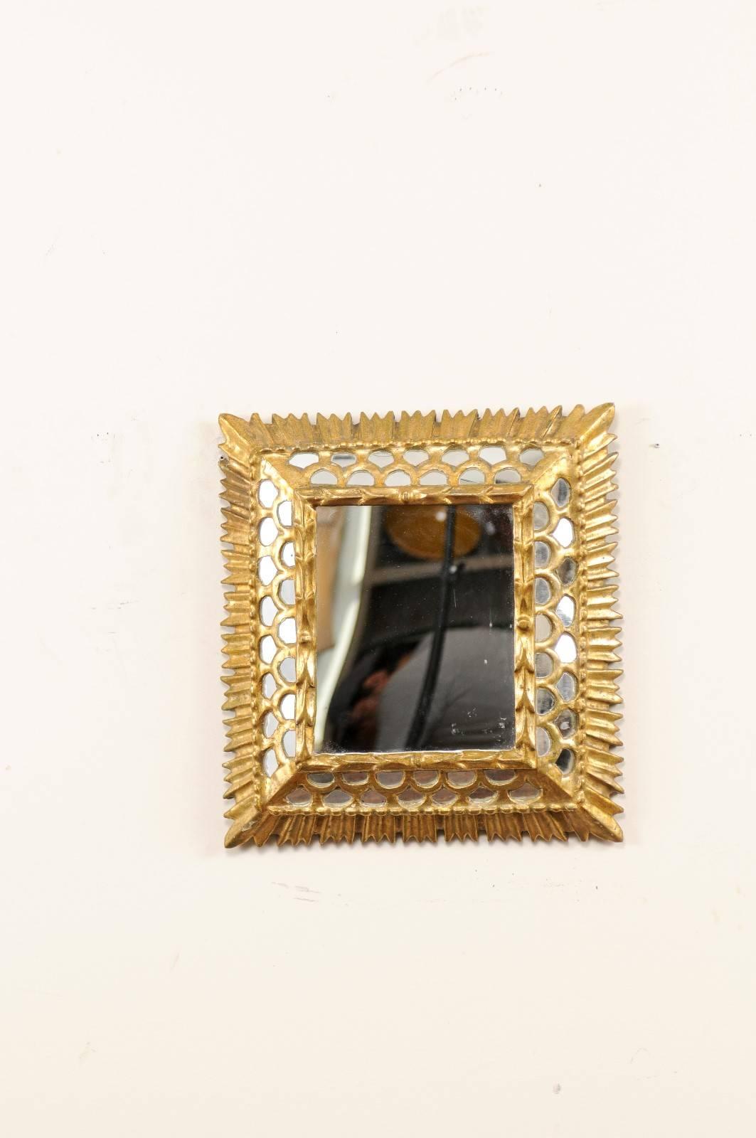 A vintage European small-sized mirror. This European small-sized gilded mirror features a raised centre surrounded by honeycomb lattice work with inset mirrors. The inner surround has tiny arrow like trim and the outer most edges have short ray tips