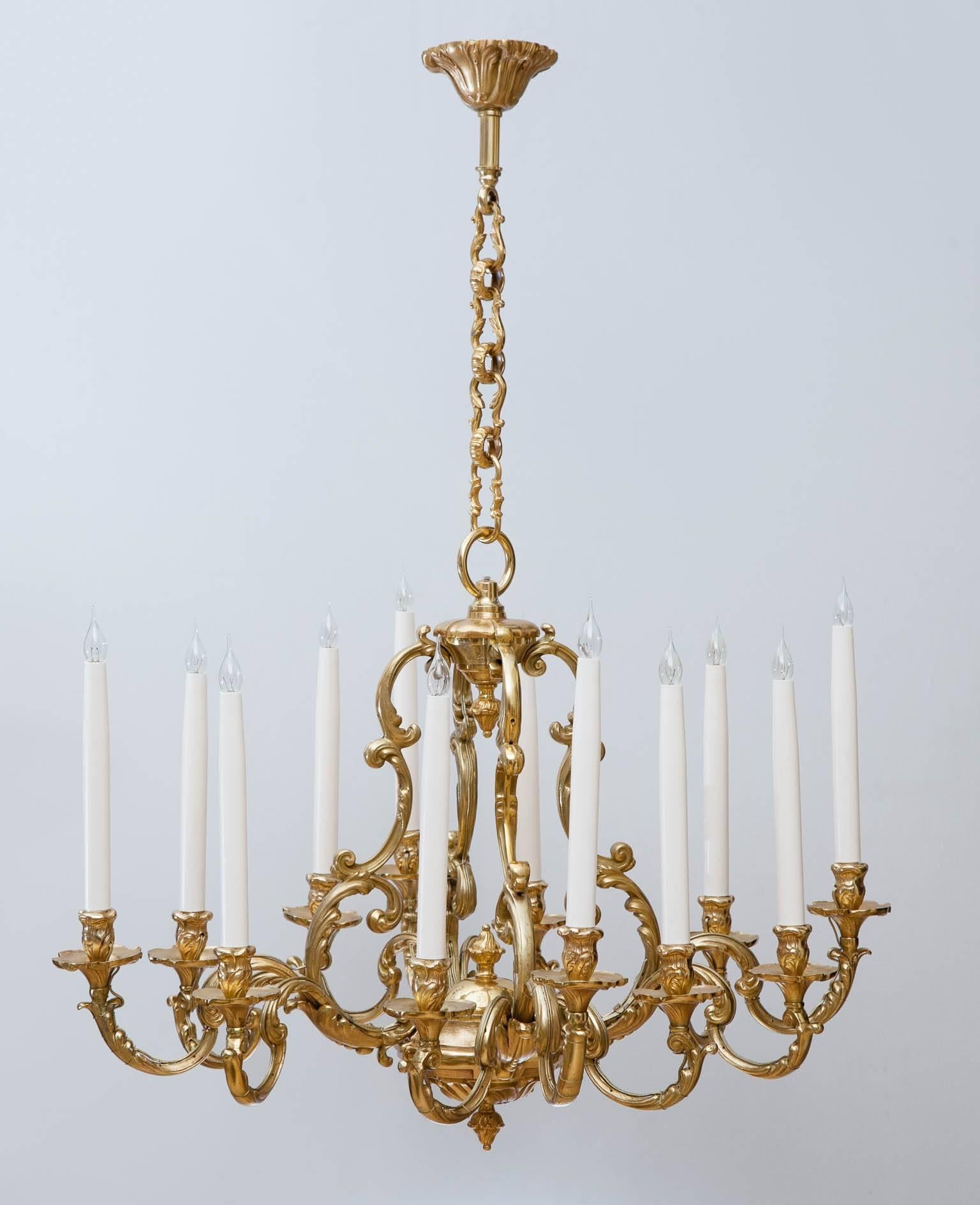 Hanging from it's own ceiling rose with fine quality decorative chain. The chandelier is supported on four shaped arms with four arms below each with three further shaped arms and tall candles. The whole decorated with finely cast and incised