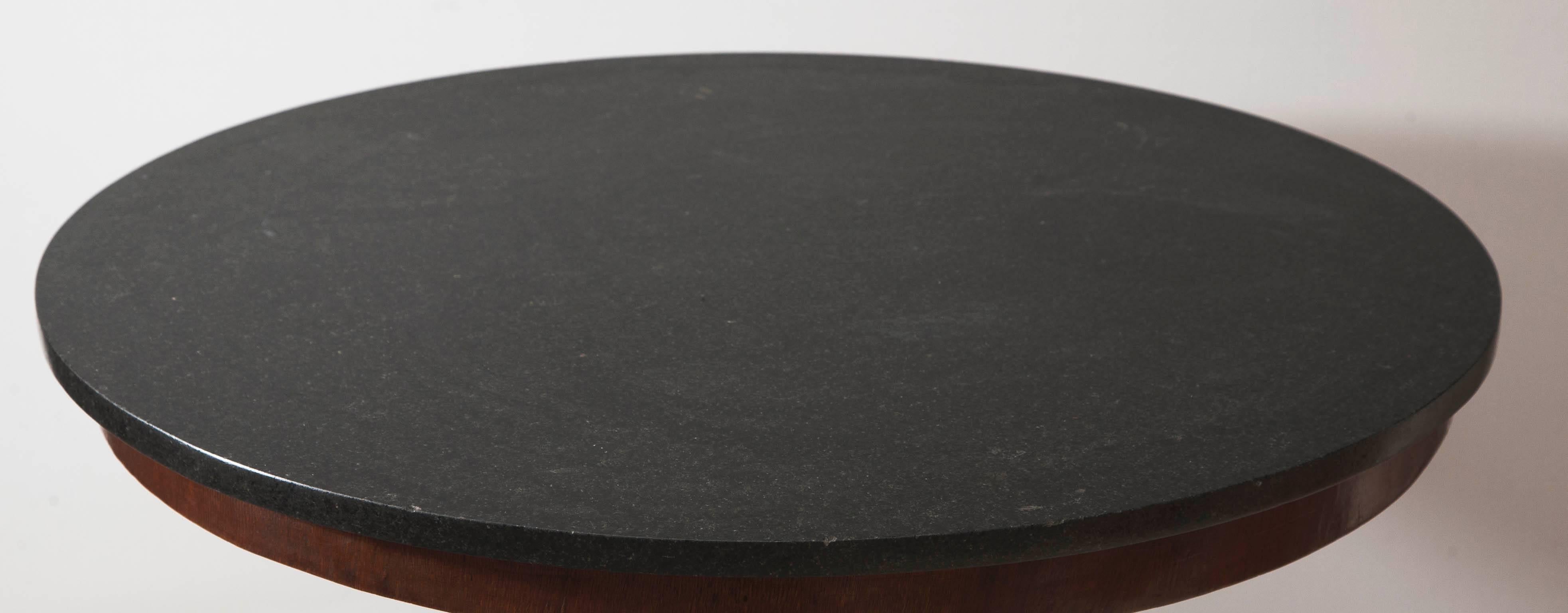Mahogany and mahogany veneer with black fossil marble top.

Handsome and plain antique round center table.