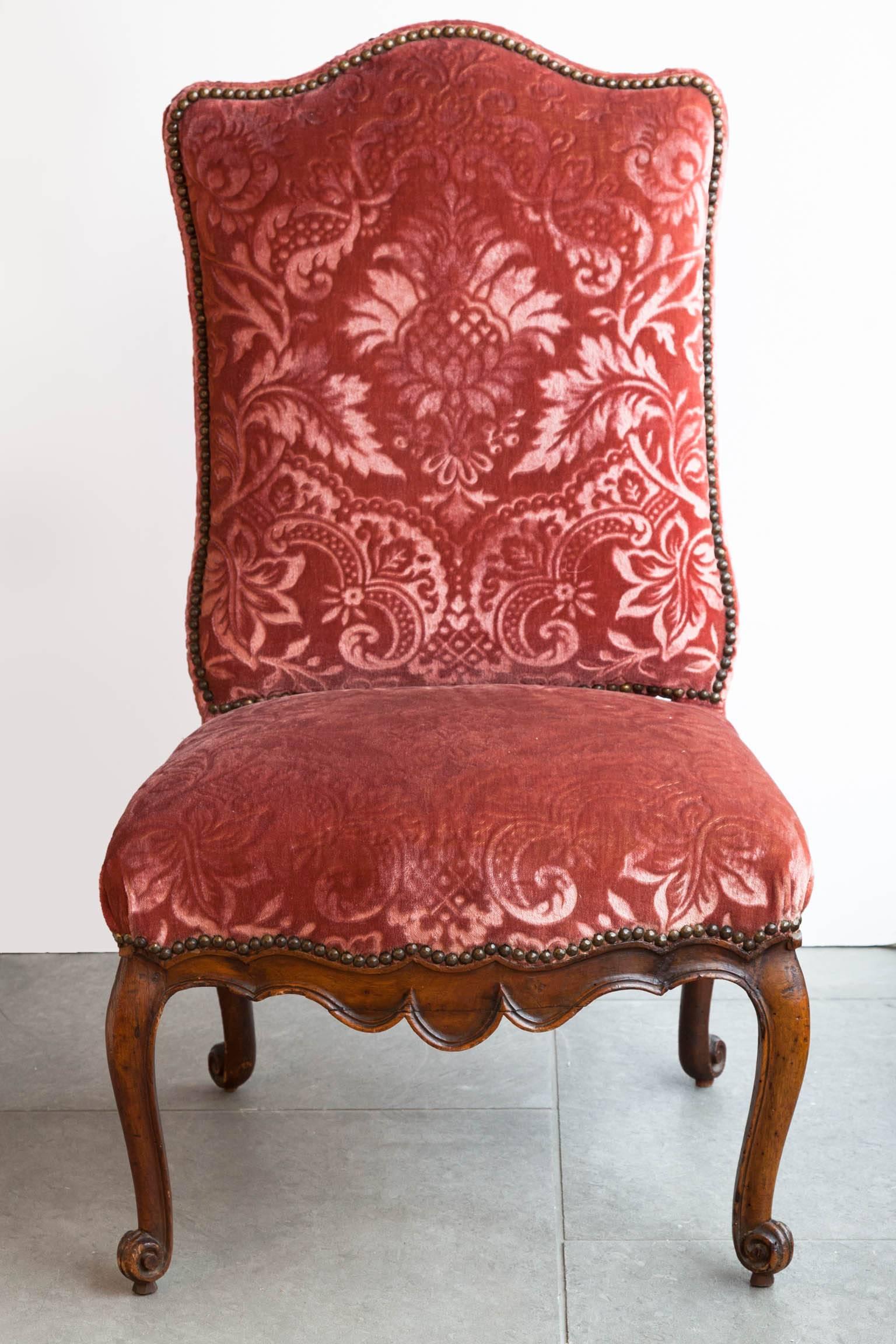With shaped back and carved apron. Curved legs terminating in scroll feet. 
Upholstered in dark pink cut velvet. France, circa 1740.