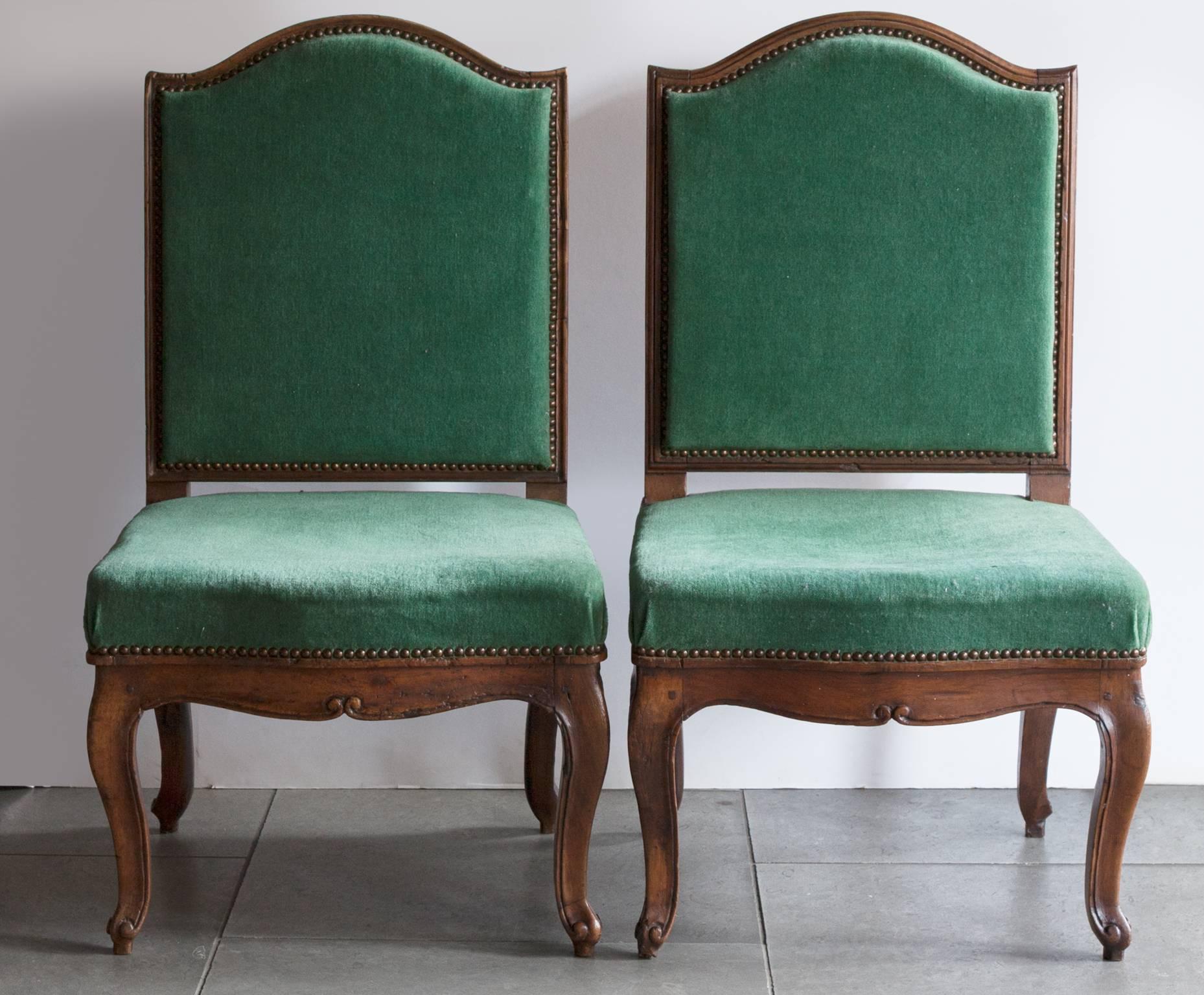 A pair of mid-18th century Provincial side chairs in carved walnut.
Cabriole legs terminating in scrolls. Upholstered in later green velvet. Some small marks to one of the seats,
France, circa 1750.
