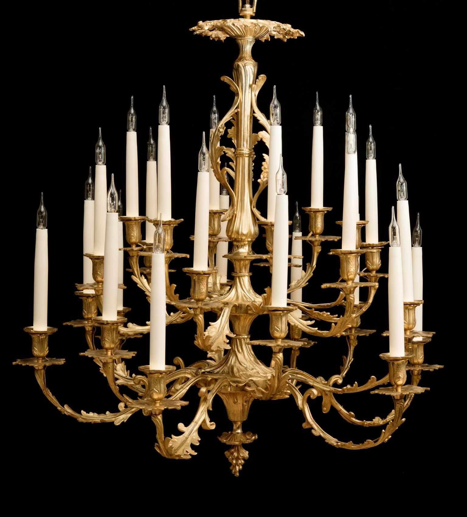 With 24 French candles on finely cast and incised ornate tiered arms decorated with acanthus leaves. Extending from a central ornate rod with further leaves and Rococo curling shapes, terminating in a vine finial. 
Currently electrified for the UK