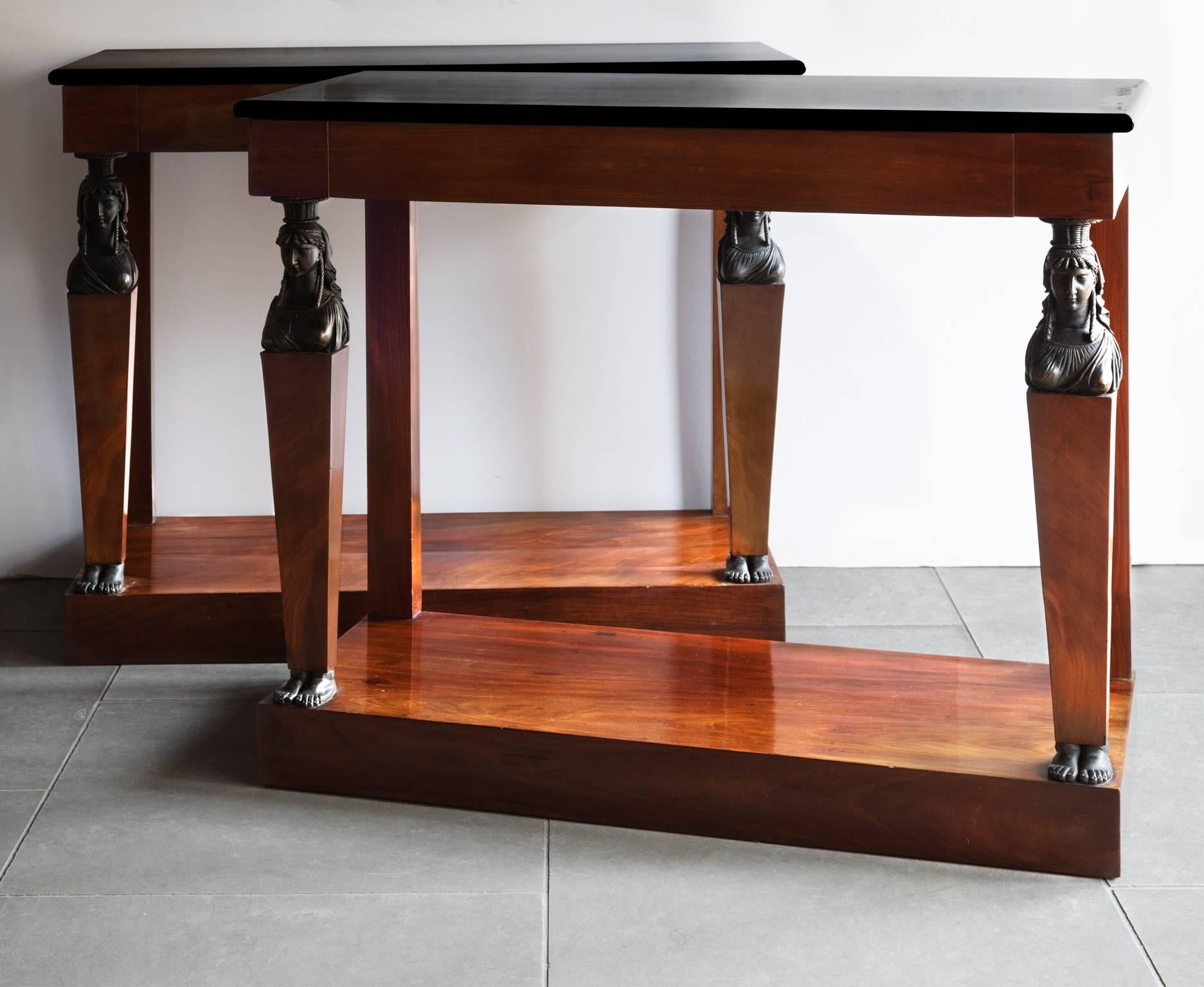 Side Tables. Polished black marble top. Built of oak and veneered in mahogany with carved female caryatic figures after the antique ebonised to imitate bronze. Central frieze drawer on each. 
France Circa 1799-1804 Epoque Consulat. 
