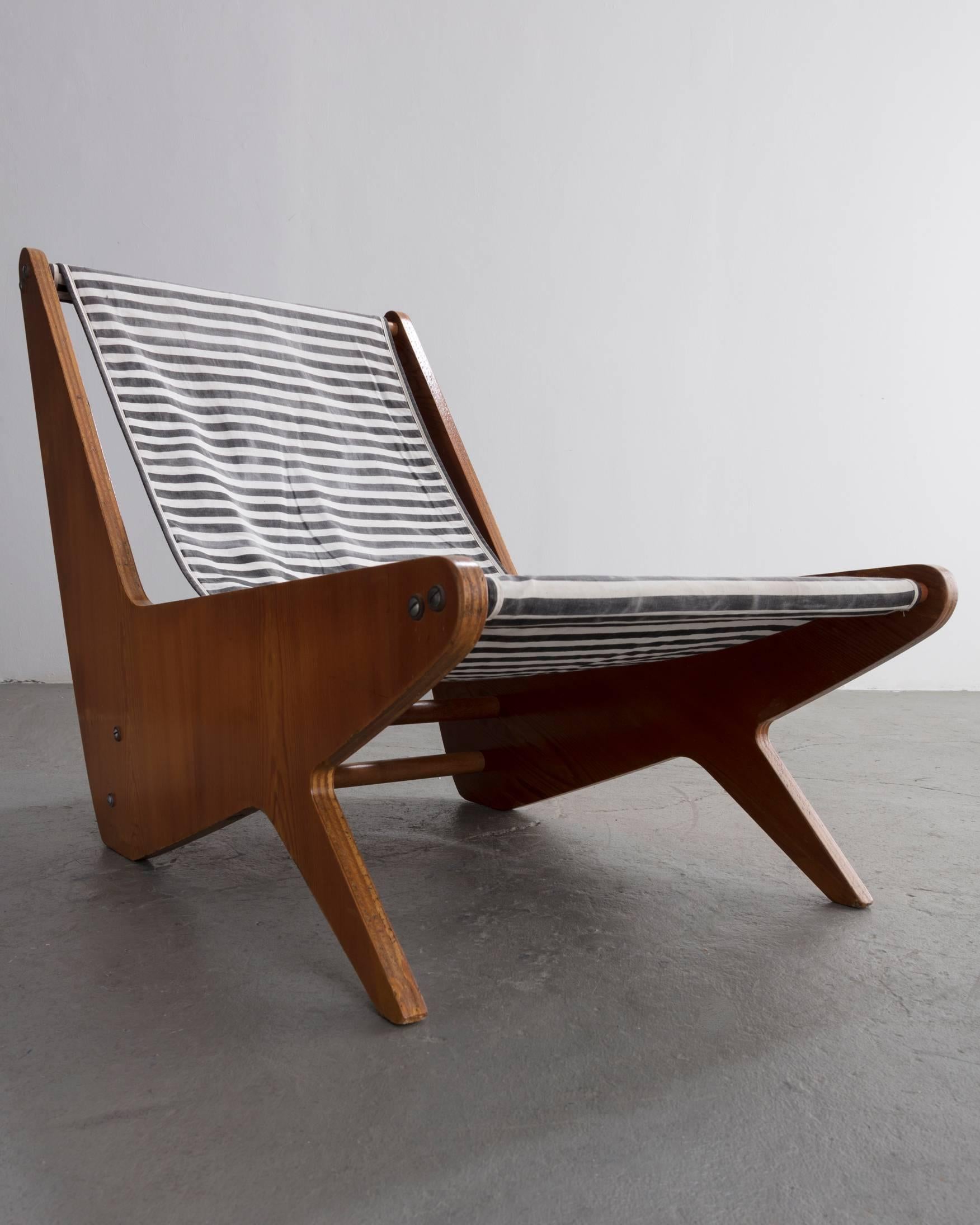 Early plywood lounge chair with black and white striped slung canvas seat. Designed by Jose Zanine, Brazil, 1950s.