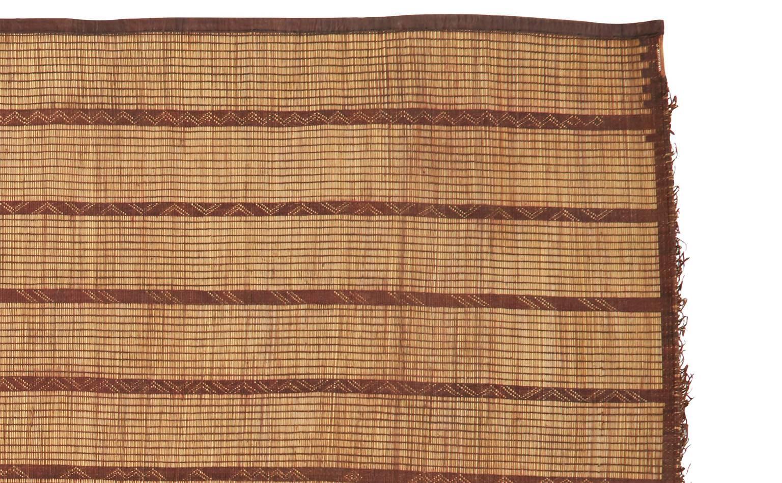 Handwoven from dwarf palm leaf fibers and goat leather.
Flat-weave.
From the desert region of Mauritania.
Measures: 13' x 9'