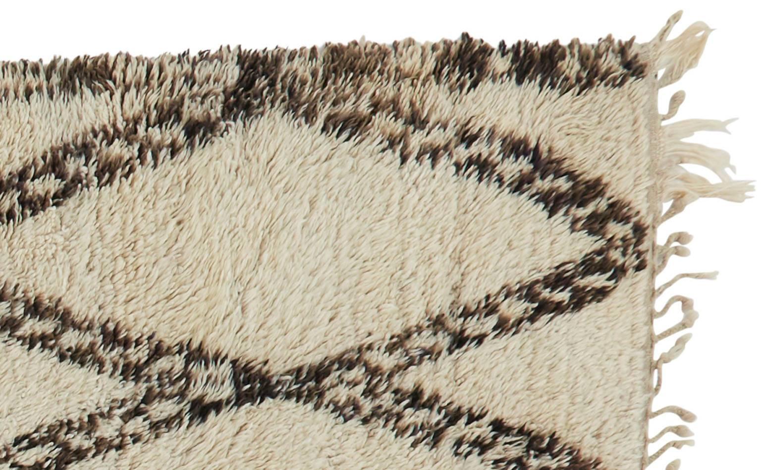 High pile sheeps' wool.
Decorated with brown, grey or black natural dyes in abstract, geometric.
Made by Berber tribes in the atlas mountain region of Morocco.
Measures: 6'3 x 11'3