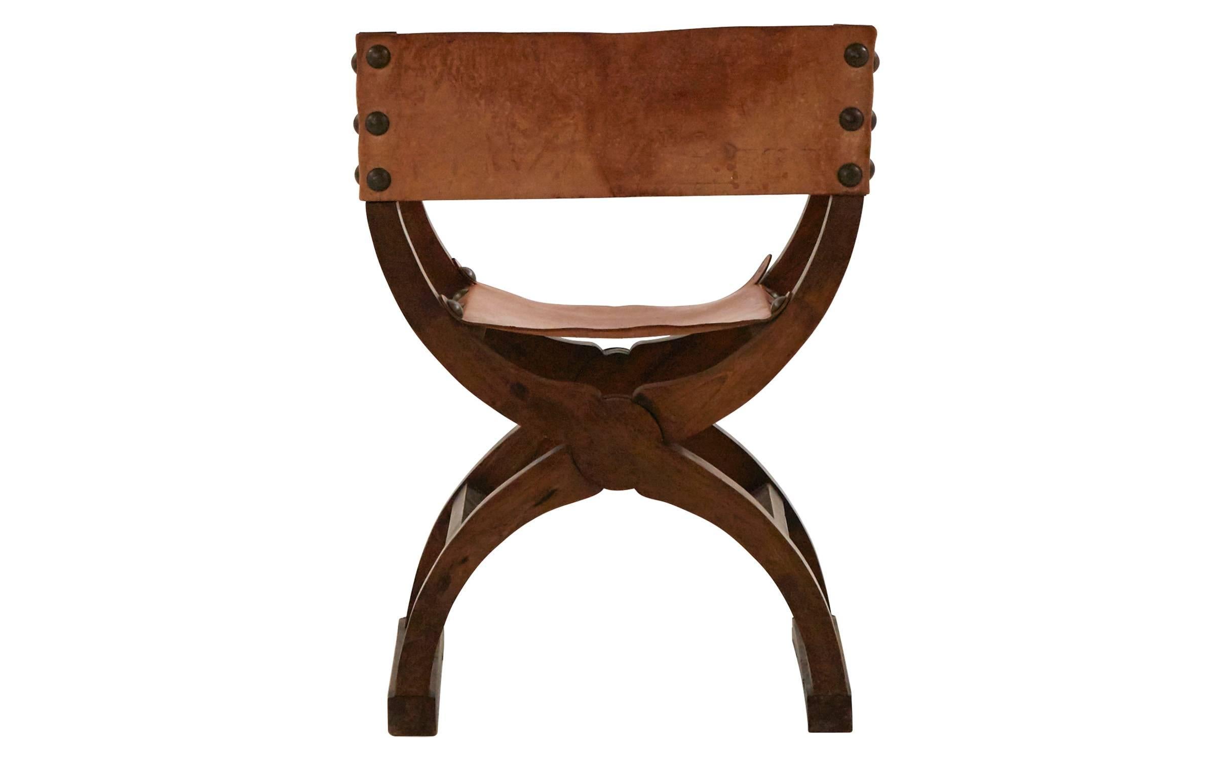 Original leather.
Hand-carved walnut wood.
Folding frame.
Antiqued nailhead,
19th century,
Italian.

Dimensions:
overall: 22.5" W x 17.5" D x 31.5" H. 
Seat height: 17.5" H.
Arm height: 25.5" H.