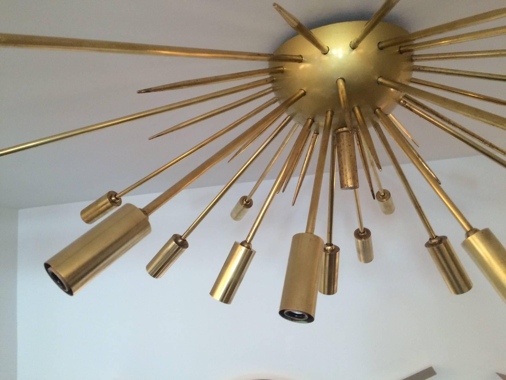 Iconic Sputnik as a ceiling flush mount fixture attributed to Stilnovo.
19 polished brass light stems radiating from a matte
brass semi-circular center. Additional brass 