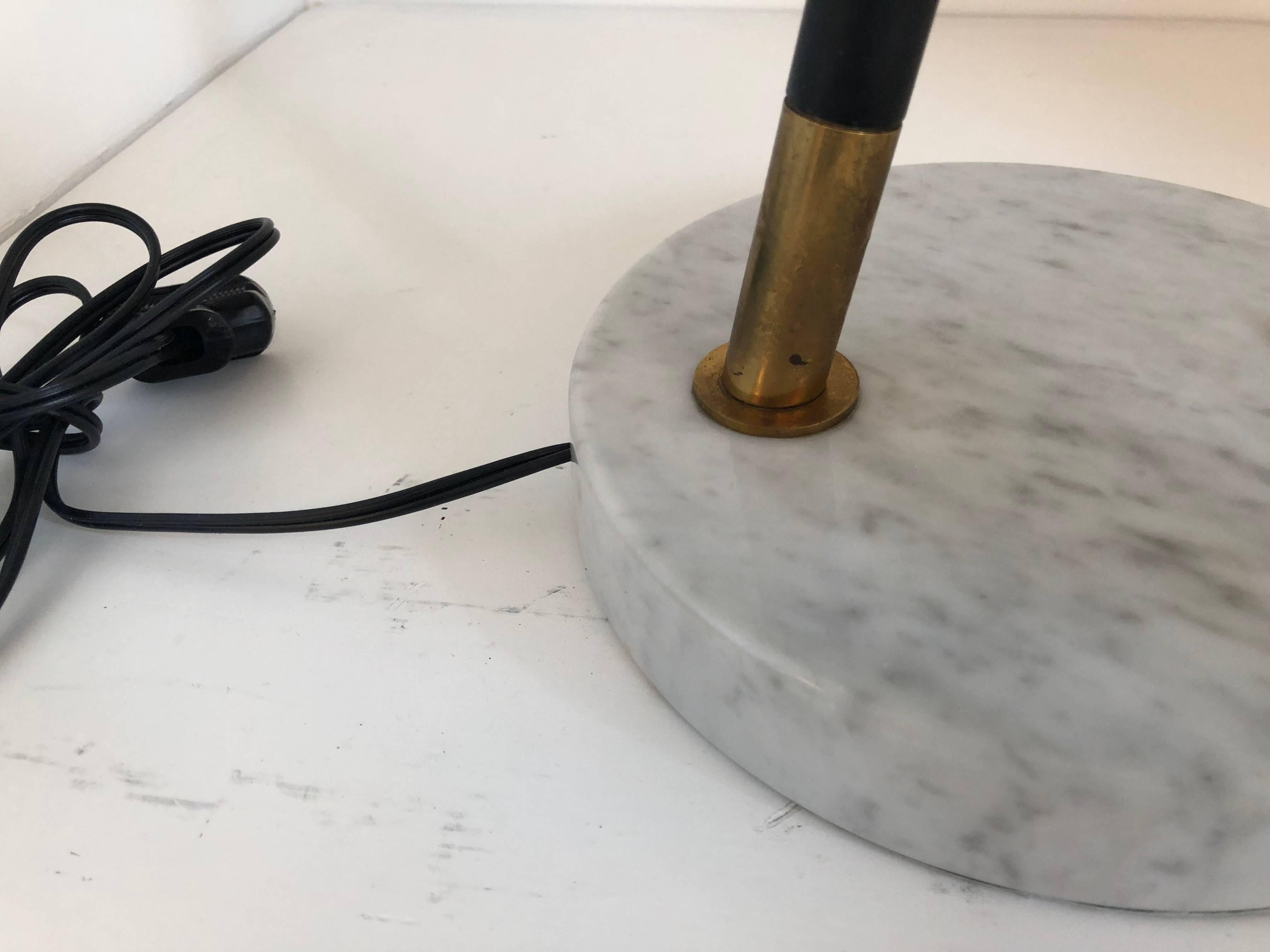 This Italian task lamp was manufactured by Stilux/Milano, features a carrara marble base, adjustable arm and stem in black with brass and an acrylic white shade. 


