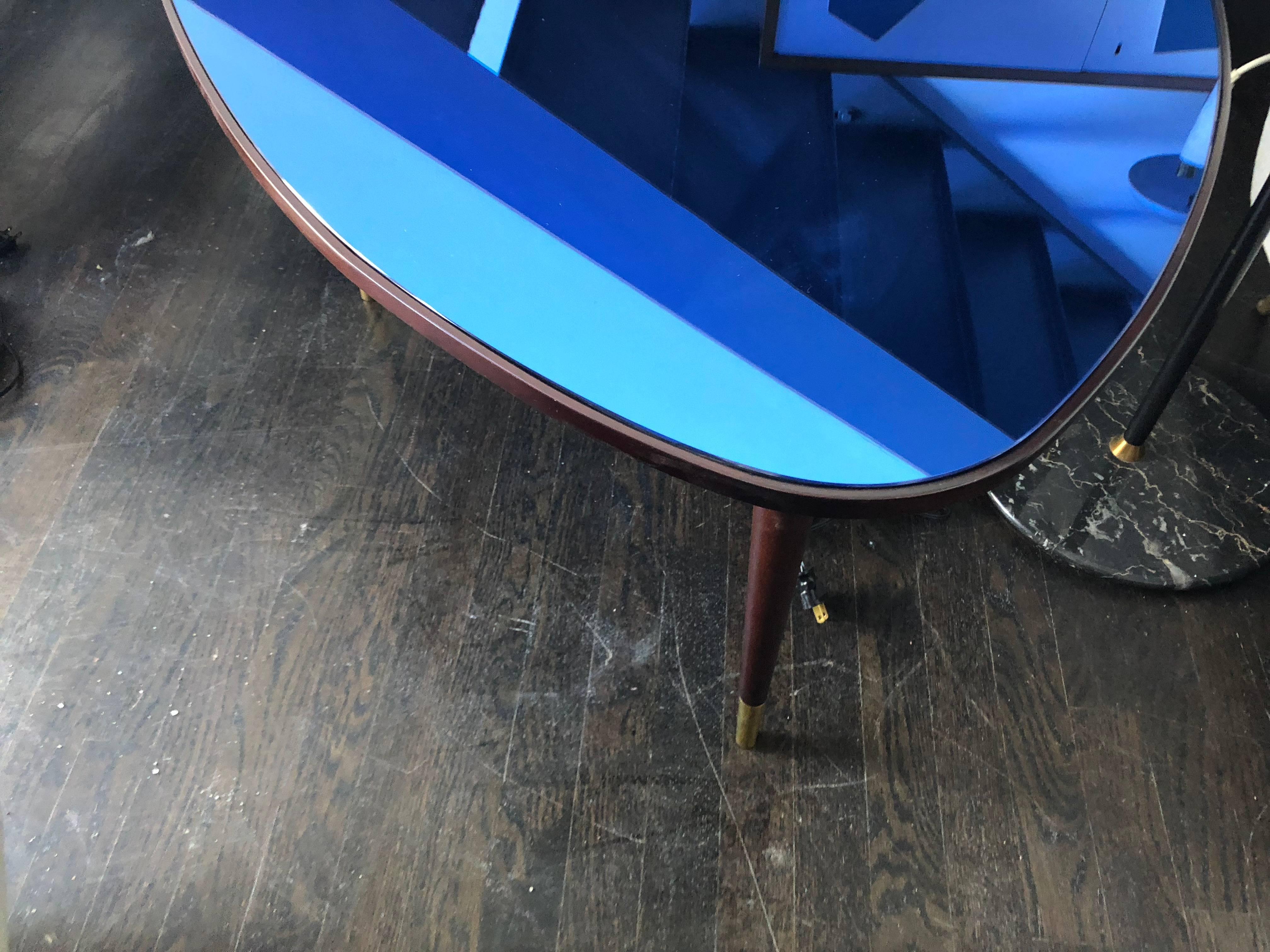 Beautifully carved tri-sided mahogany coffee table resting on three mahogany legs with brass caps and topped by original cobalt mirror (inset). Designed by Osvaldo Borsani and manufactured in Italy in the early to mid-1960s. All original.


     