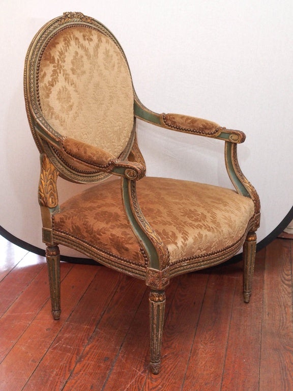Pair of French 19th century Louis XVI style carved giltwood and green paint armchairs.
Medallion back with acanthus leaf motif on arms front. Gold tapestry velvet fabric in good condition.
