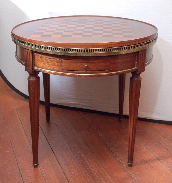 19th century walnut  bouillotte table with grey marble top, brass gallery , two drawers on each side and two sliding leather shelves on each side with four fluted tapered legs.
The table comes with a removable checkered top ( one side green felt to