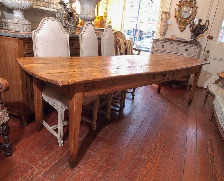 19th century French farm table made out of four planks of solid walnut. Four straight tapered legs and a 5.25