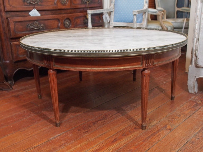 19th century French walnut  coffee table with white and grey marble , brass gallery and four fluted tapered legs.