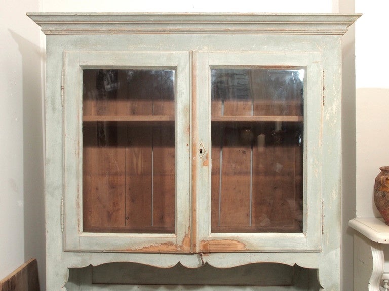 Small French 19th Century  pine rustic buffet a deux corps. 2 glass doors on the top, 2 drawers and 2 bottom doors. Wood knobs on drawers. Painted in pale green. Loss of paint.