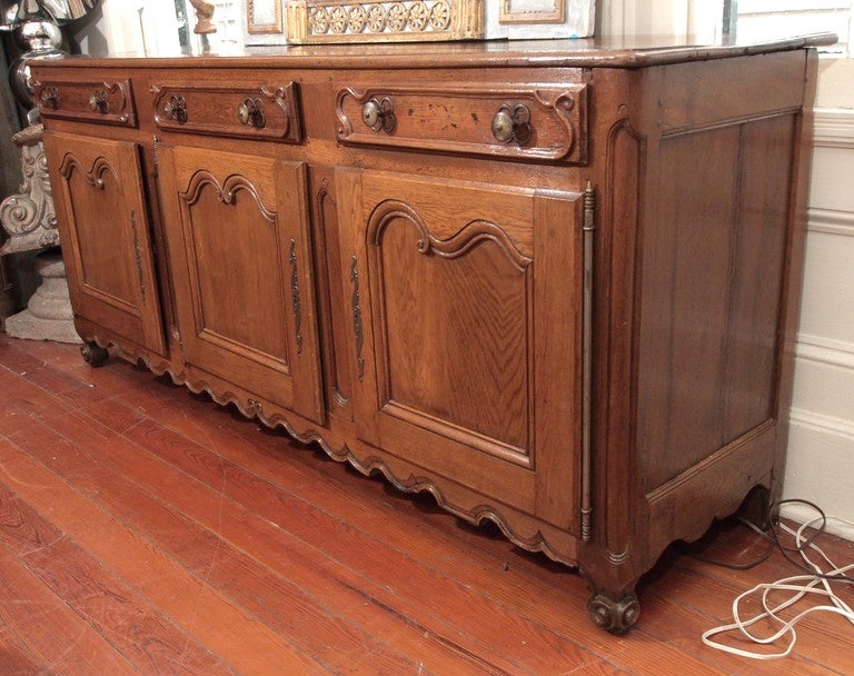 Directoire Walnut 18th century buffet from France. 4 doors, 3 drawers, round circular feet.
Provincial work.