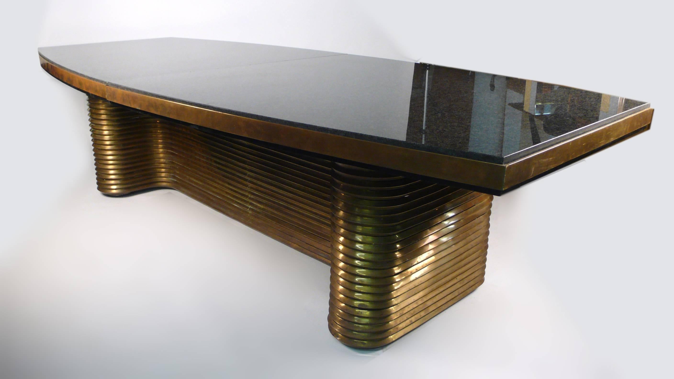 Limited edition dining table designed by Edward Moore and hand forged in his studio in Quebec. The base is crafted from extruded architectural bronze and the top from two slabs of polished black granite. This is an exqisite table for the discerning