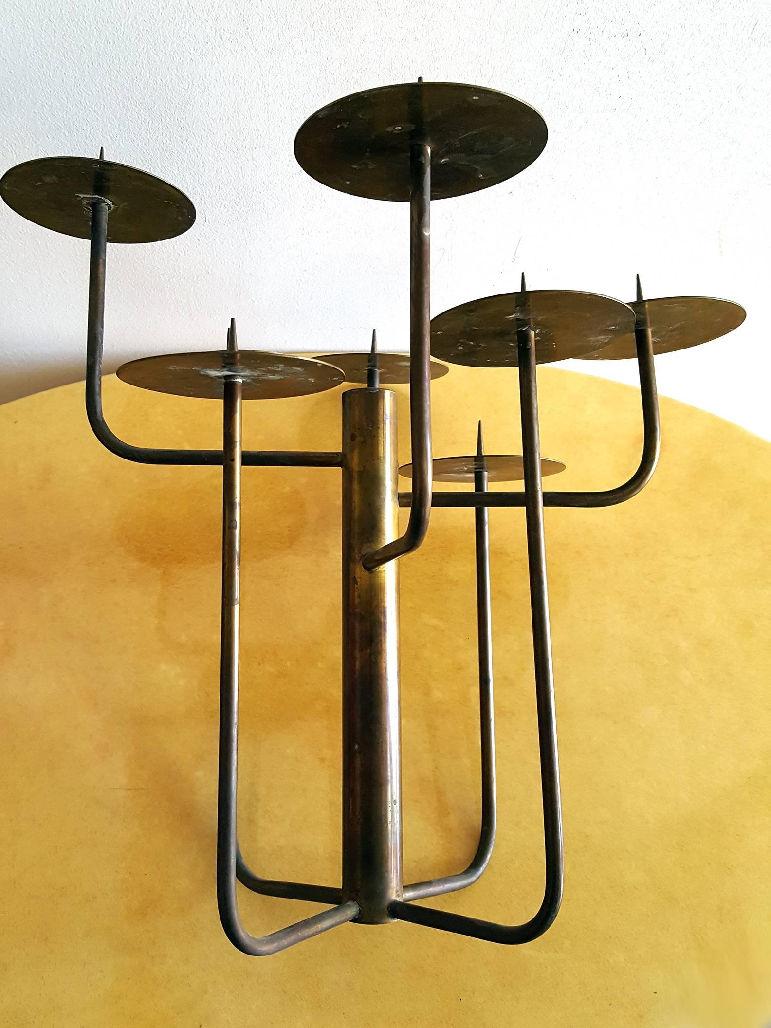 1950s brass studio candelabra comprised of eight brass arms emanating from the circumference of a larger central column. Each rod terminates with a removable drip plate adorned with a solid brass spike. Beautiful patina.

Each drip plate measures