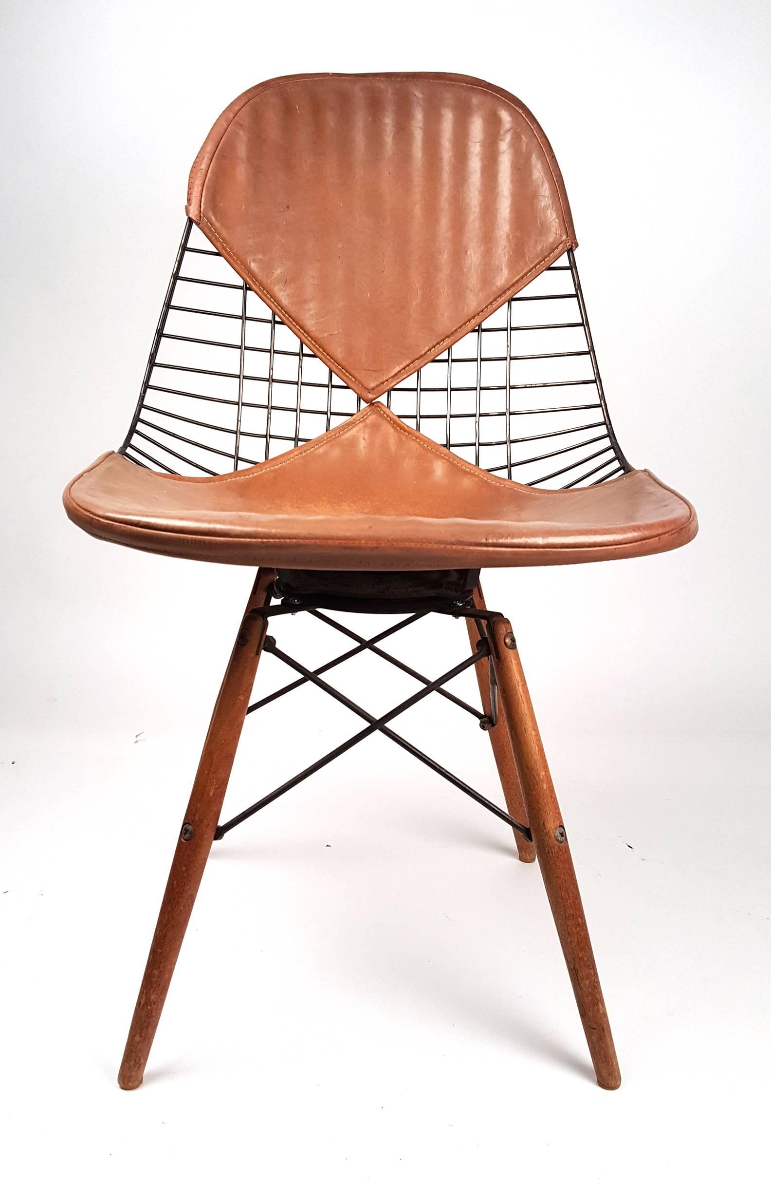 Early and rare Eames for Herman Miller PKW-2 dowel leg swivel chair with leather bikini cover. (Gorgeous patina!) No breaks or rewelds. The base is original to the seat. The original screws attaching the seat to the base are present. The paper label