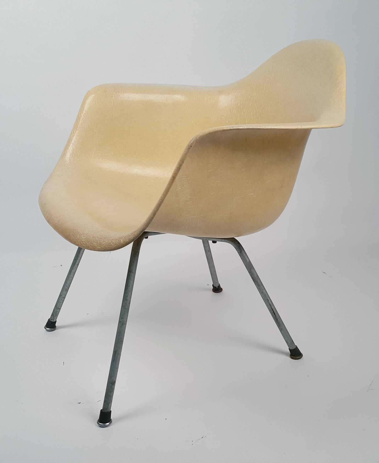 Charles and Ray Eames diseñaron un reposabrazos bajo con base en X. Base de zinc original, tornillos originales, deslizadores de arranque originales. Carcasa de fibra de vidrio apergaminada de transición temprana con grandes soportes de