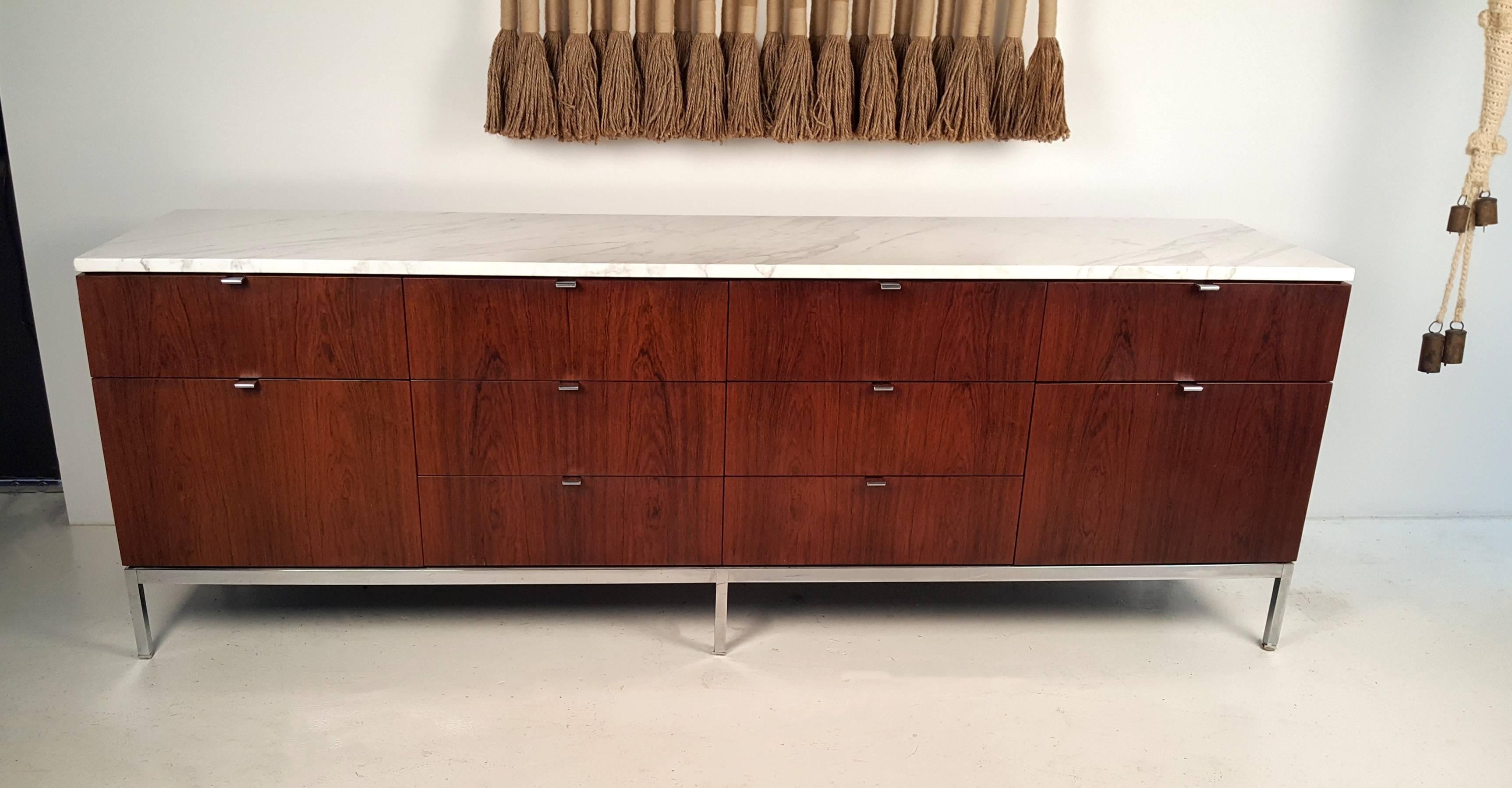 Ten-drawer Brazilian rosewood credenza with Carrara marble top designed by Florence Knoll for Knoll International. Chrome-plated base and hardware and oak interiors. Very good original condition.