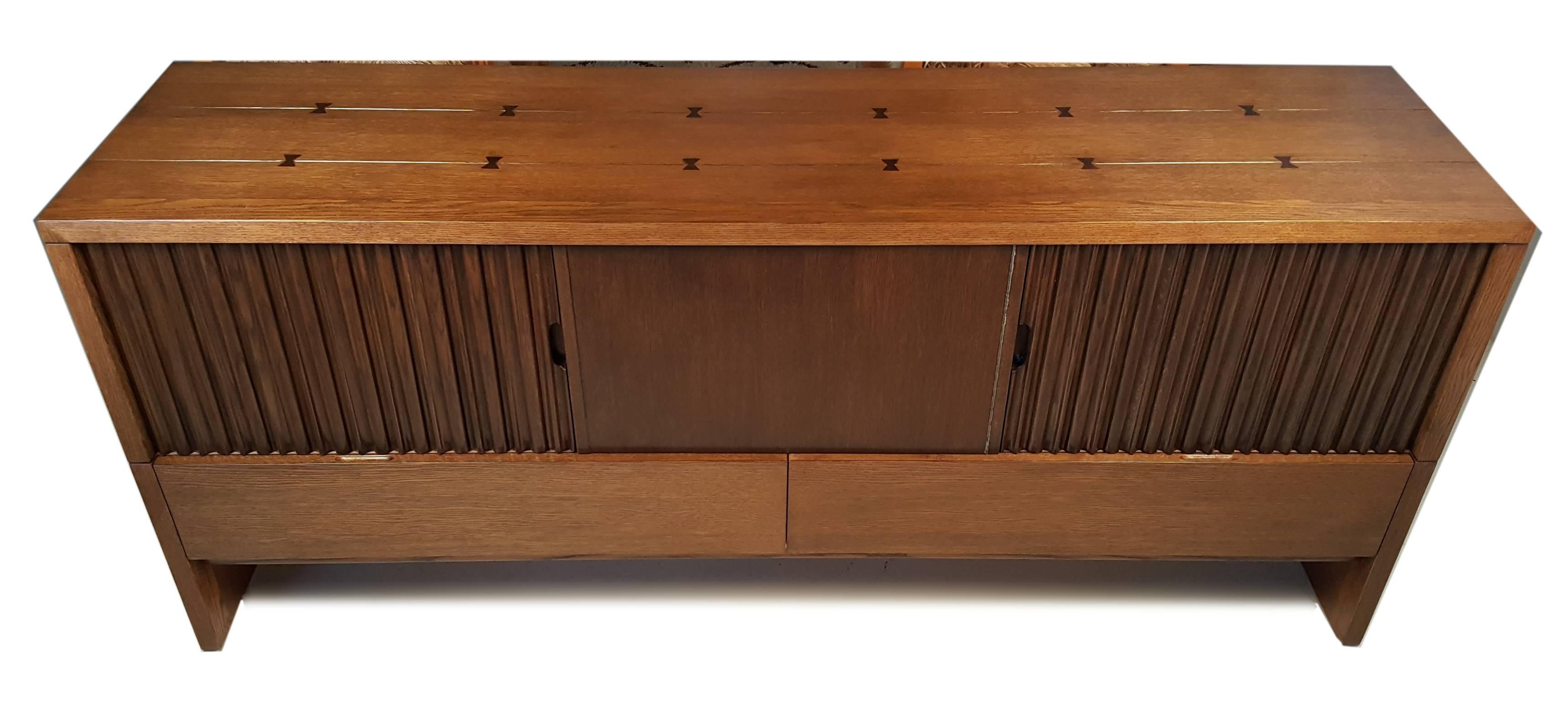 Stunning oak credenza by Harold Schwartz for Romweber. The inlaid butterfly joiner on the cabinet is quite striking. This sideboard is the largest from the series. It has been professionally refinished and is in remarkable condition. There is a nice