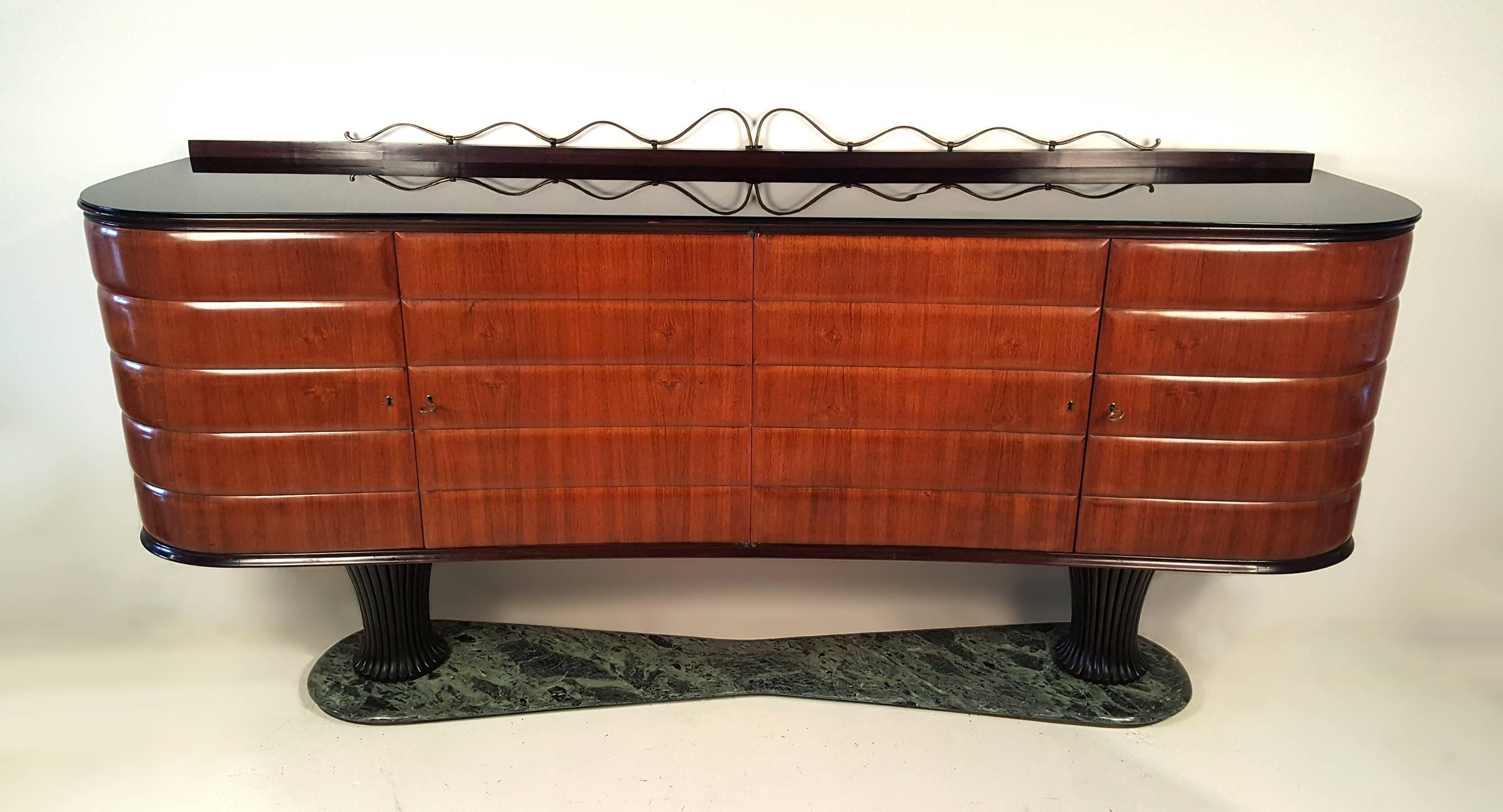 A phenomenal early Italian modernist server in sculpted Italian walnut with hand-carved mahogany bases, black milk glass top, hand-forged solid brass ornamentation and verde marble base with brushed brass reveal. An elegant and functional piece of