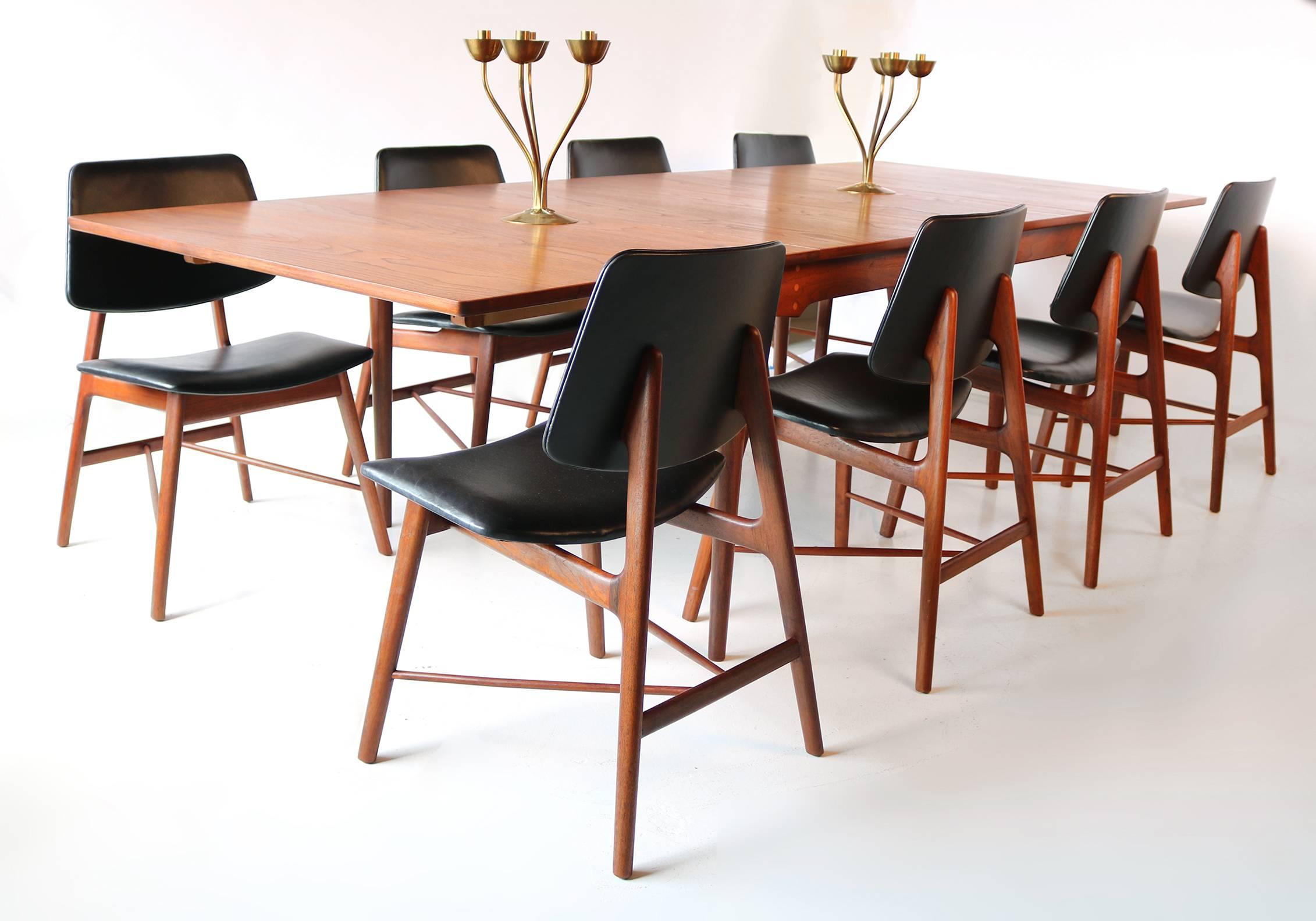 Set of eight Finn Juhl solid teak sculptural dining chairs recovered in a smooth oiled black leather and completely refinished in a waxed teak oil finish. The table measures 43w x 62L x 29