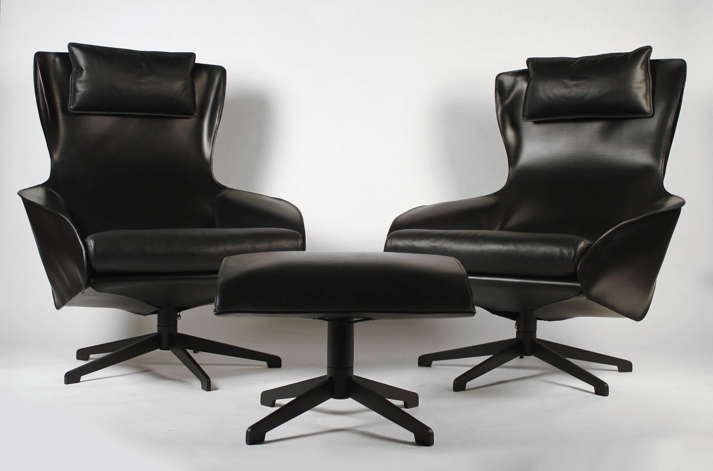 This pair of Mario Bellini model 423 cab lounge chairs are in excellent shape and only show the slightest amount of wear. They look practically brand new. The stitched black leather upholstery with the down-filled pillow gives these chairs a unique