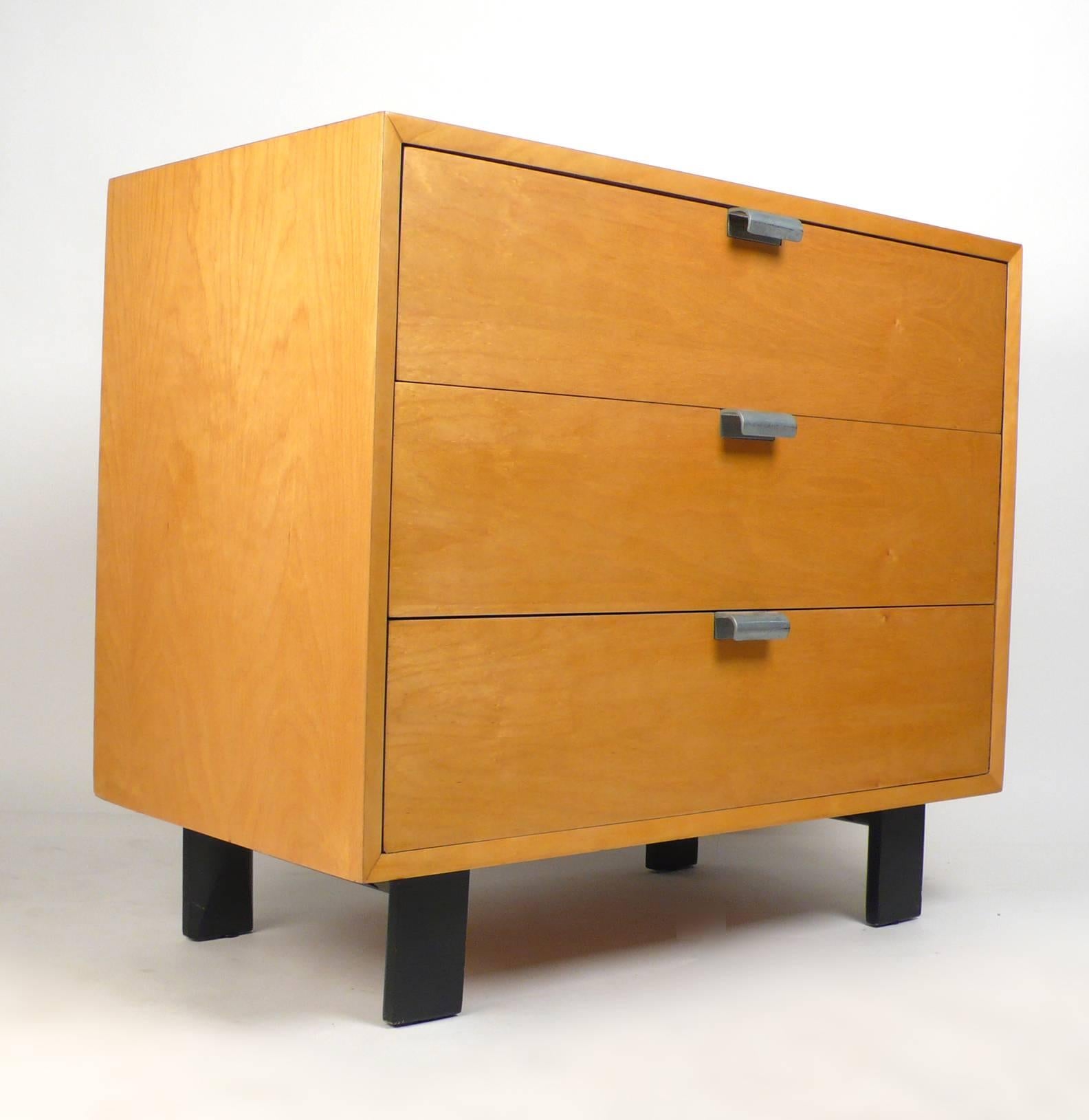Este armario George Nelson de tres cajones de la serie Basic Cabinet, un impresionante ejemplo de la artesanía moderna de mediados de siglo, encarna la elegancia atemporal. Diseñada en la década de 1950, presenta líneas limpias y sencillez, rasgos