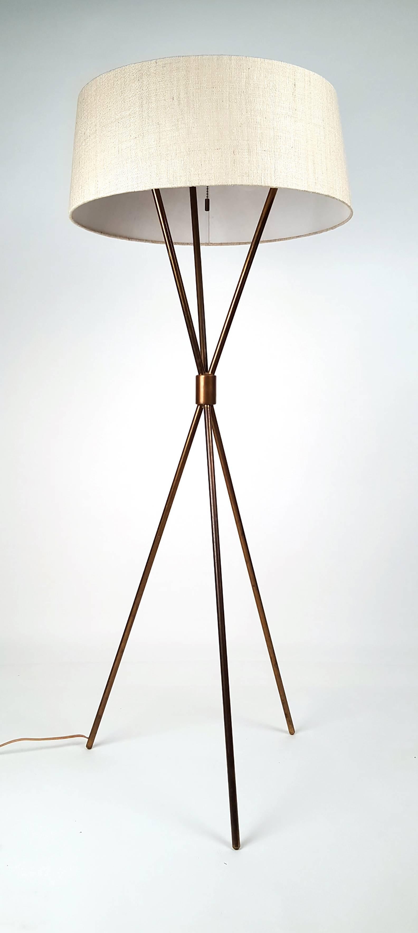 Early 1950s brass tripod floor lamp by T.H. Robsjohn-Gibbings for Hansen. Distributed by Widdicomb Furniture Company. Model #201-M. Exceptional patina. Beautiful shade. Functions as intended.