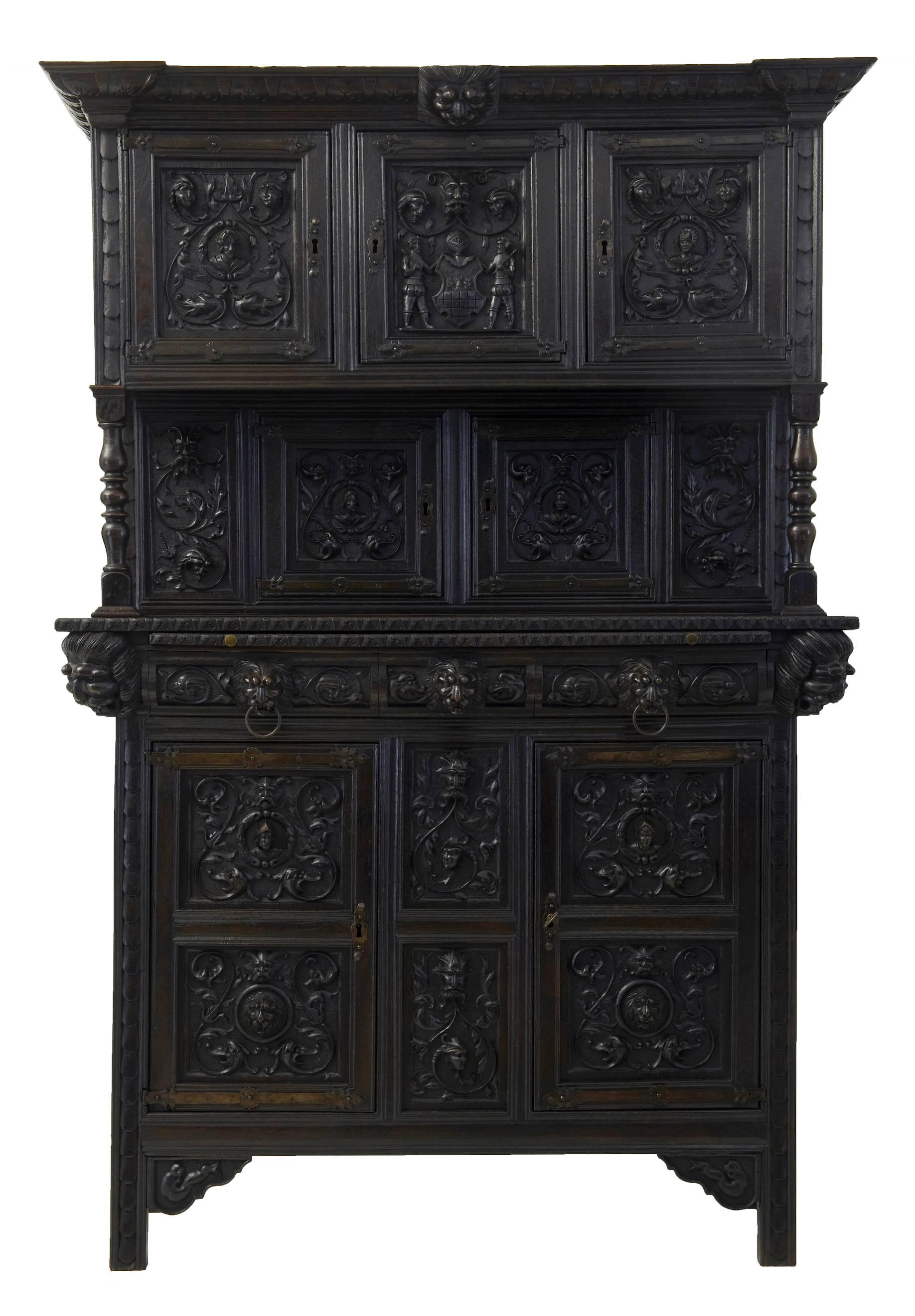Imposing french Gothic influenced cupboard circa 1830.
3 tiers comprising of 2 sections. 3 carved panel doors over a double door cupboard with turned supports, bottom section with brushing slide, 2 drawers and cupboard with shelf.
Dark oak