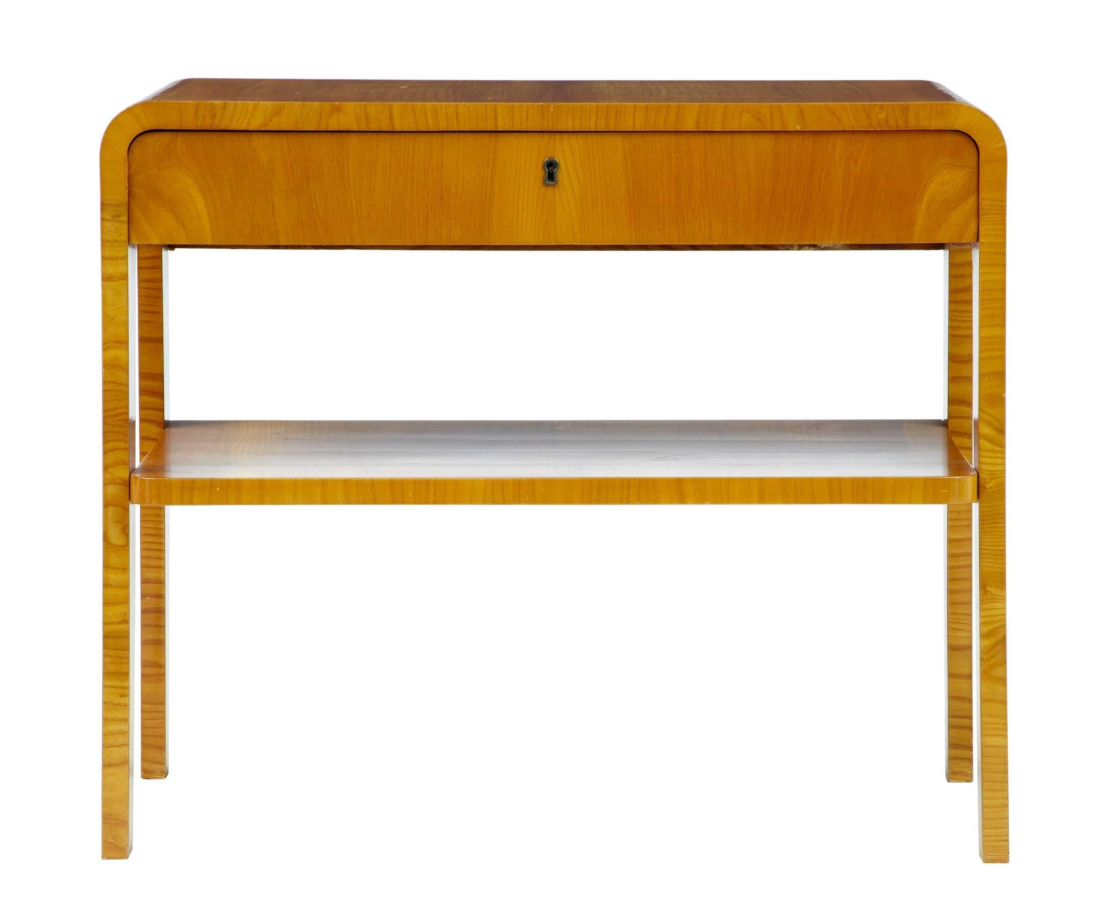 Fine piece of Scandinavian design in this multipurpose side table, circa 1950.
Flowing form made in good quality birch veneers.
Single drawer with single shelf below.
Measure:
Height 23 1/2