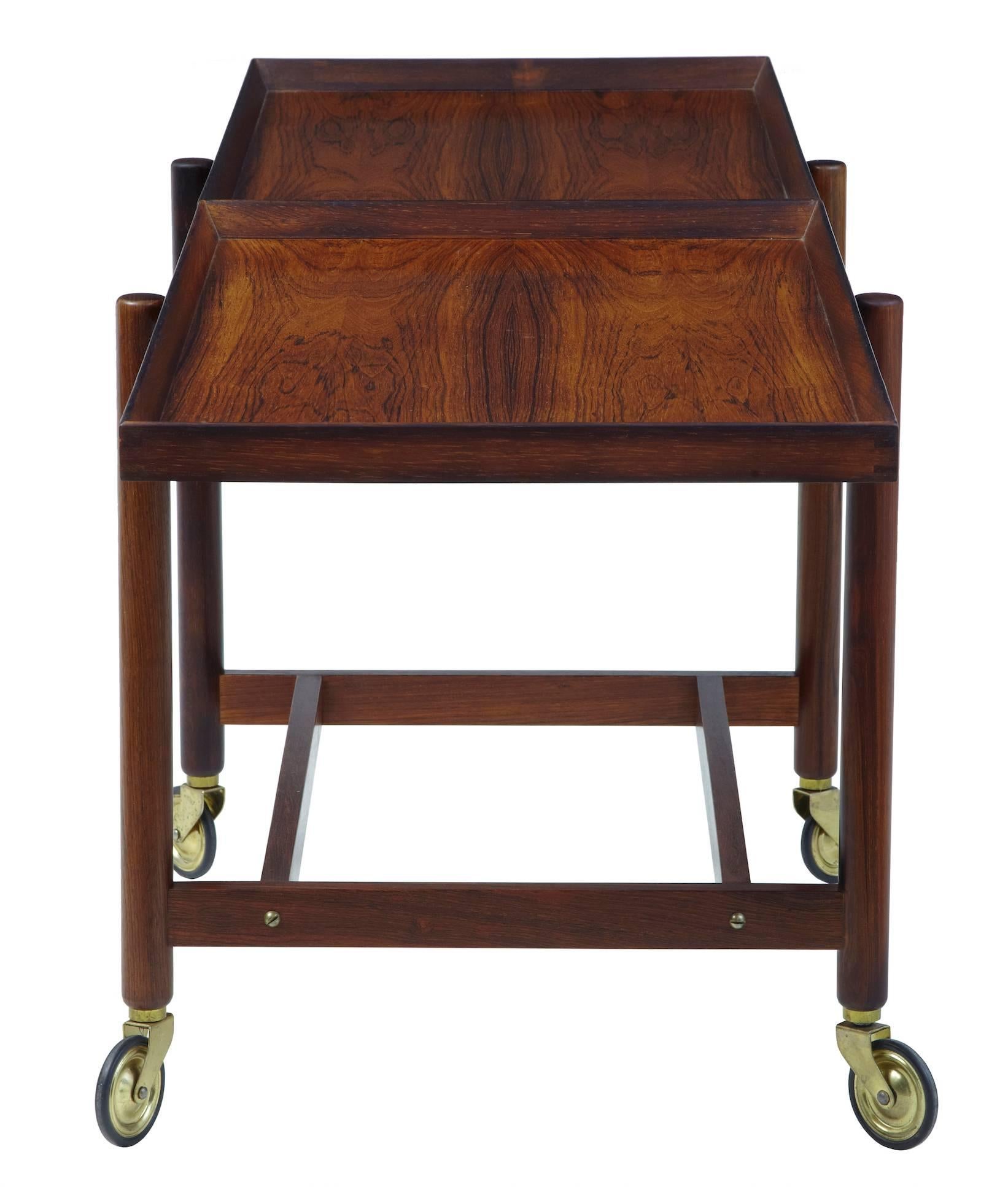 Striking rosewood trolley by well-known designer Poul Hundevad, circa 1960.
Sliding top and removable bottom tier which can be placed alongside the top tier to double the serving length.
Standing on brass wheels with rubberised tred.

Measures:
