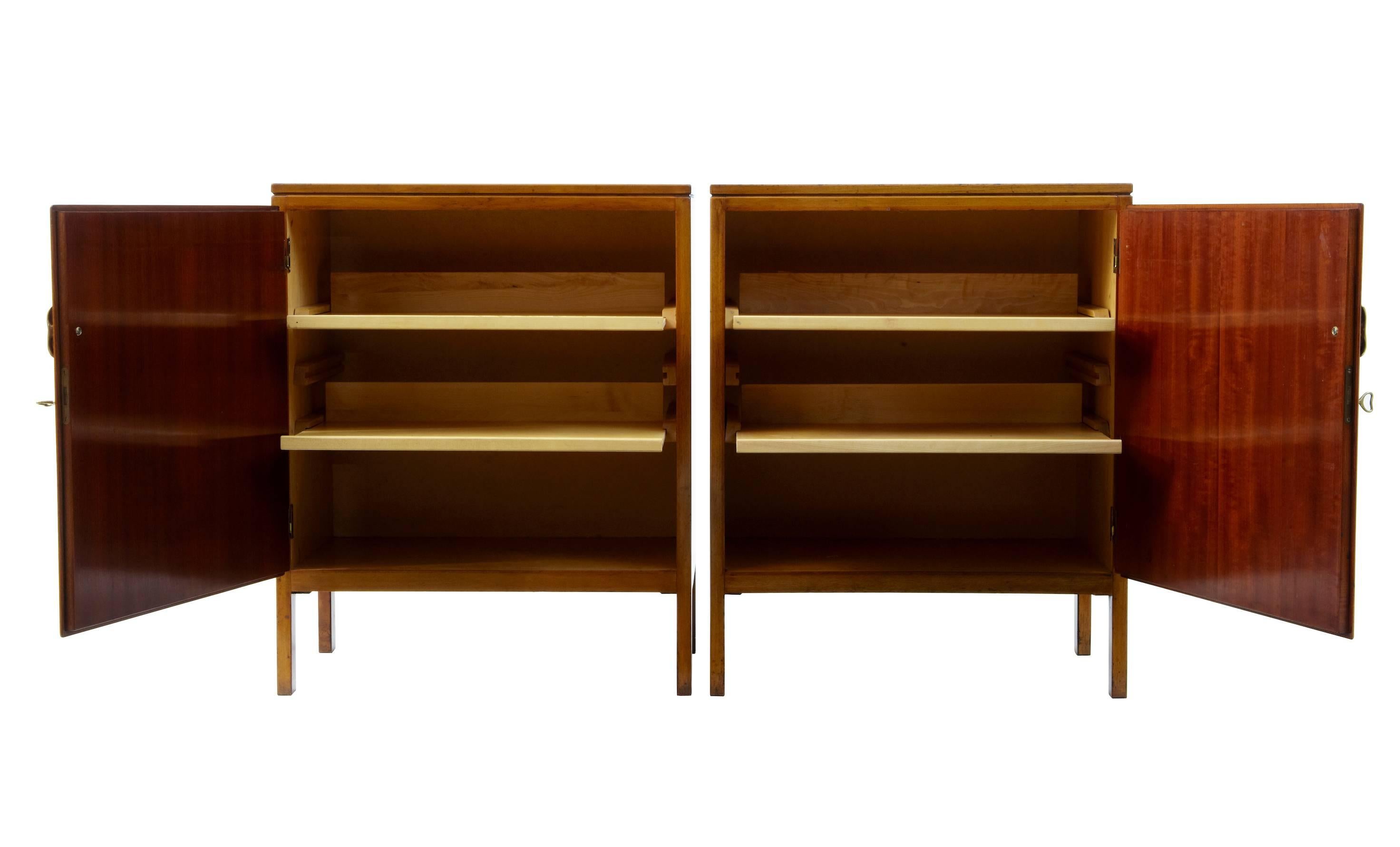 Fine pair of david rosen designed cabinets produced by nordiska kompaniet circa 1955.
Cross banded top.
Left and right opening doors, reveal 2 press drawers.
Labelled and stamped on the reverse.
Evidence of use with surface marks (please see