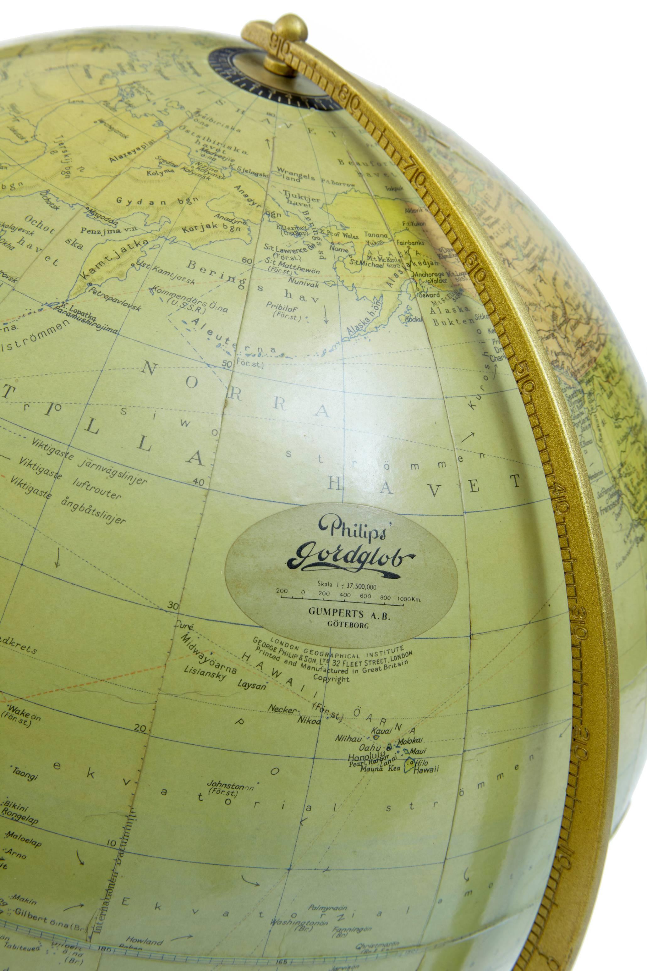 Swedish globe, circa 1930.
By Philips of Goteborg, printed in England.
Papier mâché.
Standing on Art Deco bakelite stand with inset compass.
Light paper damage near greenland.

Height: 17 1/2