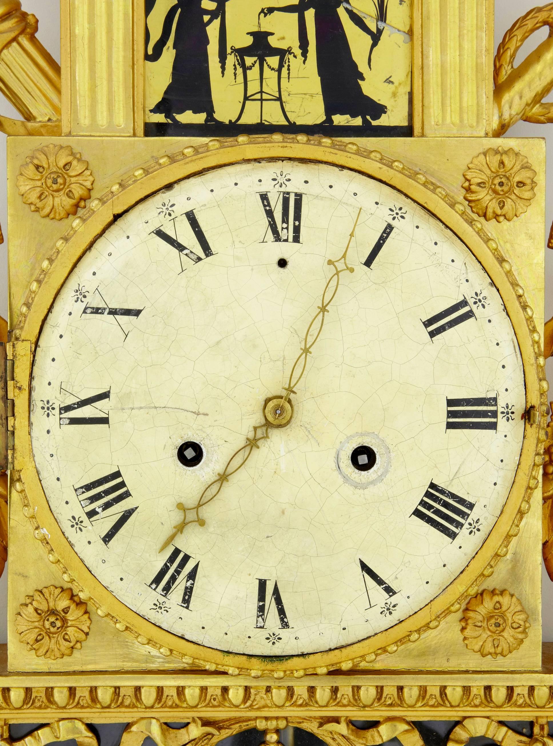 Fine quality Swedish wall clock in the empire taste, circa 1840.
Beautifully carved, surmounted with doves. Two silhouette eglomise glass panels ( 1 of which has a break.)
Craquelure to clock face with some rubbing and wear.
Original glass.

We