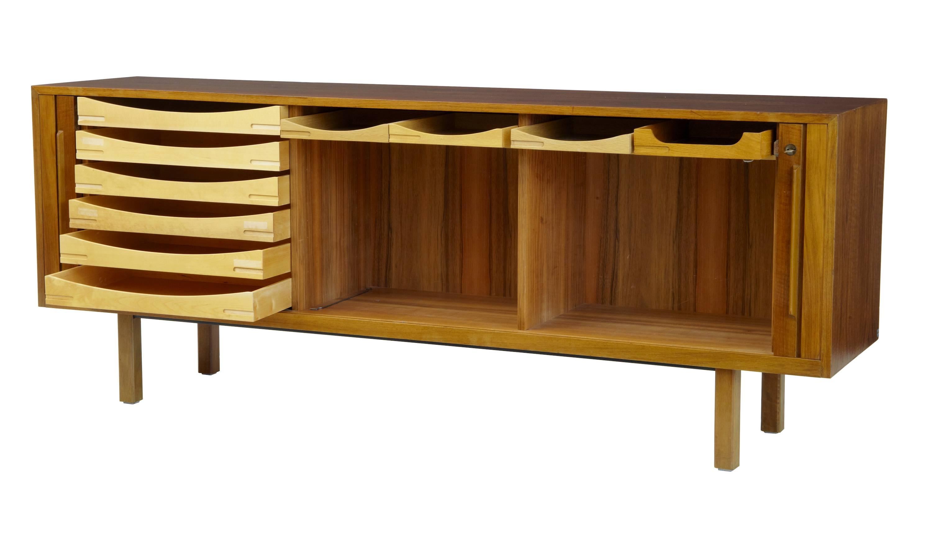 Good quality sideboard by Swedish makers Atvidabergs, circa 1965.
Tambour fronted which opens to reveal a semi fitted interior.
Three compartments, left hand side with a bank of six drawers, the other two sections with two drawers in the top (1