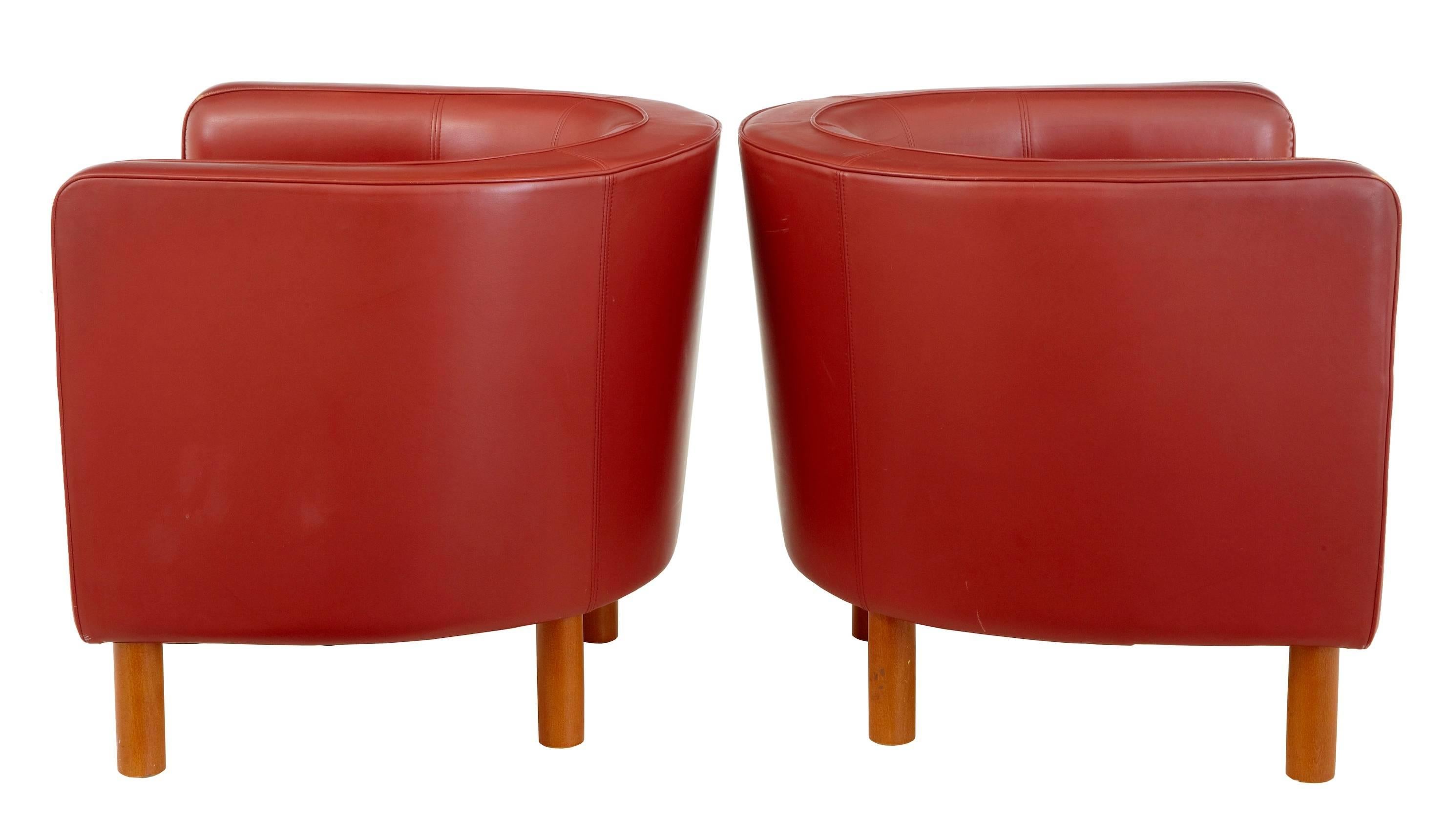 Fine quality leather lounge club armchairs in the Art Deco taste.
Upholstered in rusty red leather.
Beech round legs and exposed front under frame
Very comfortable and stylish.

Some wear to leather piping, one scuff to the side